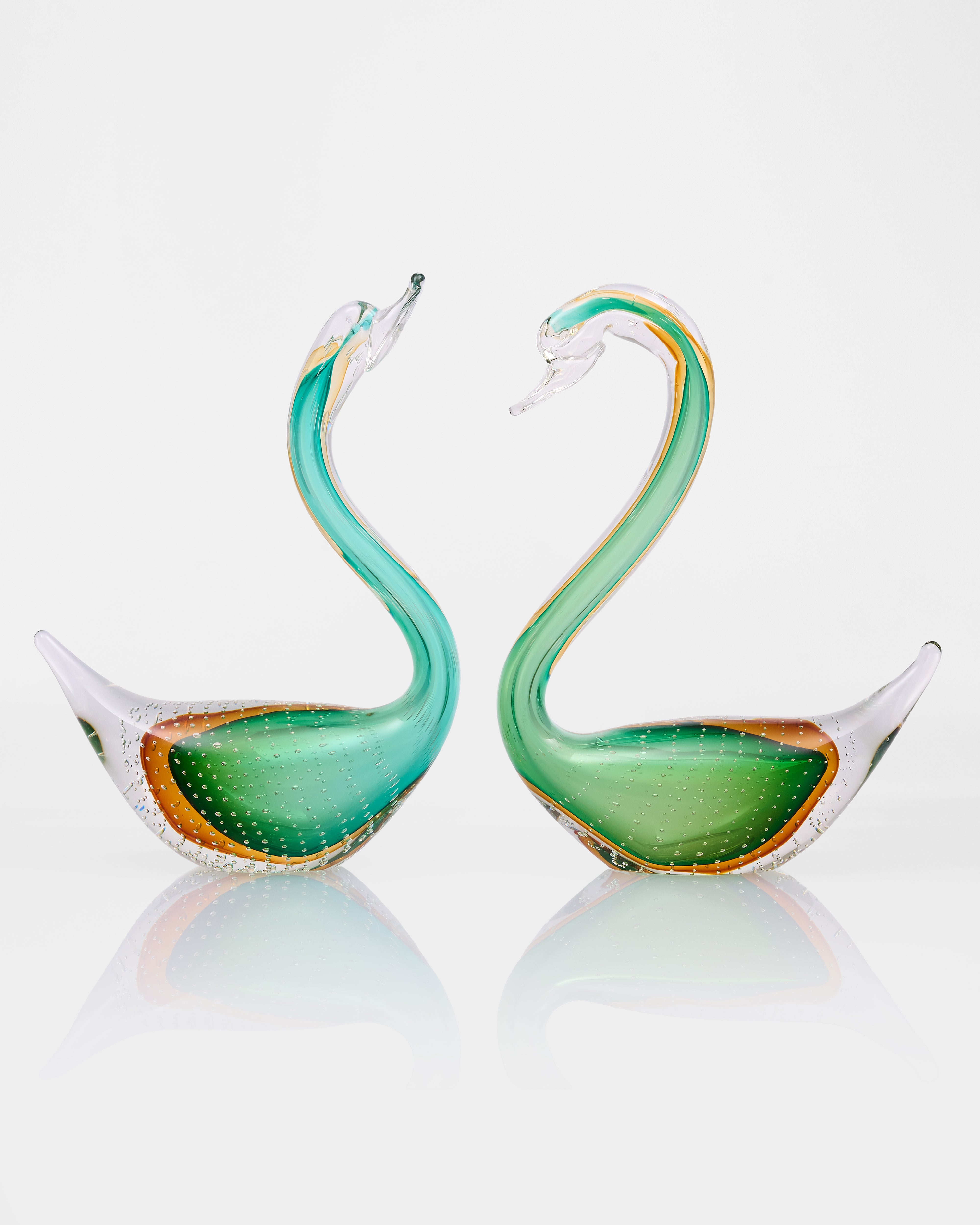 Two green glass swan-shaped decor on a white background