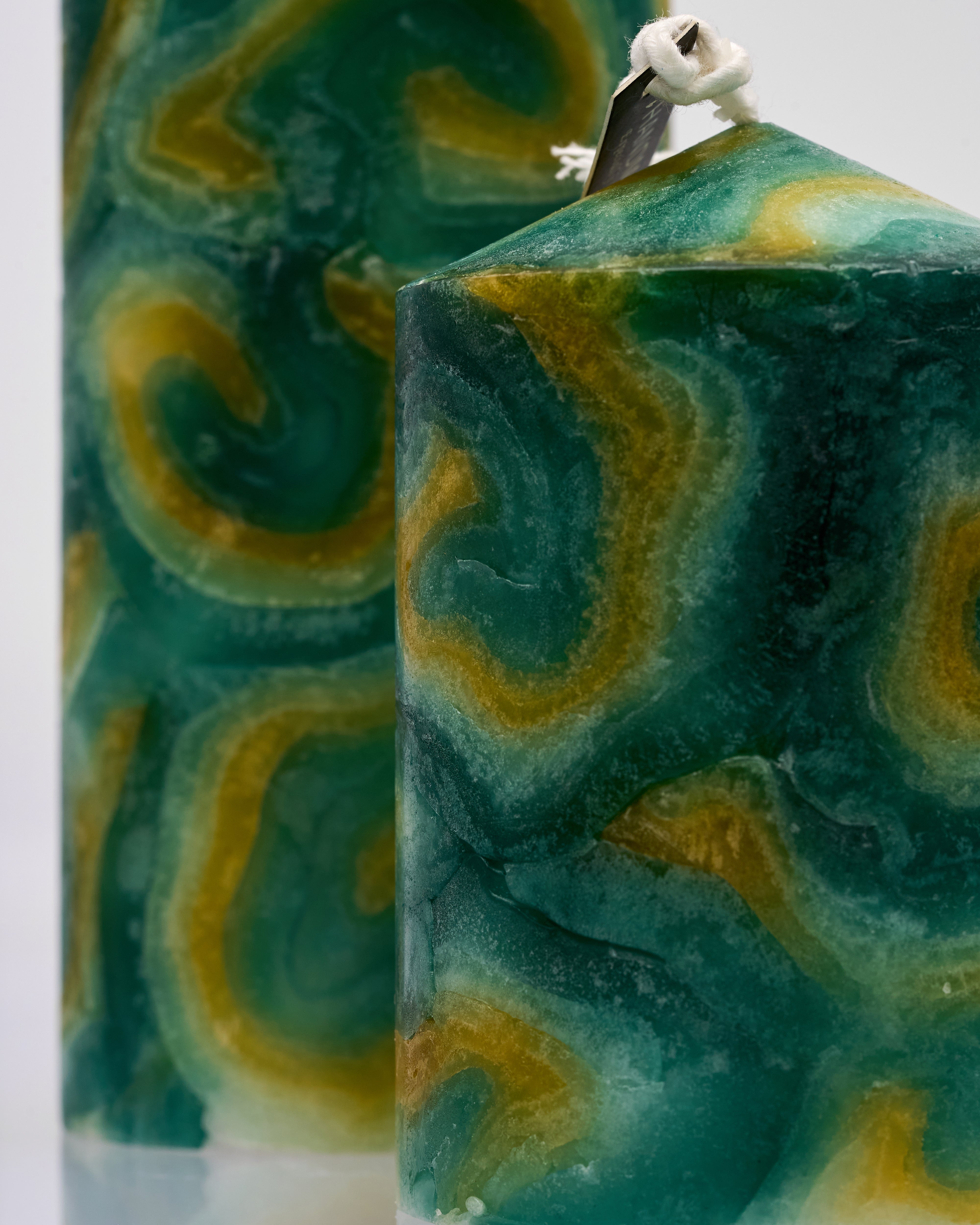 Marbled green and yellow candle with a white wick.