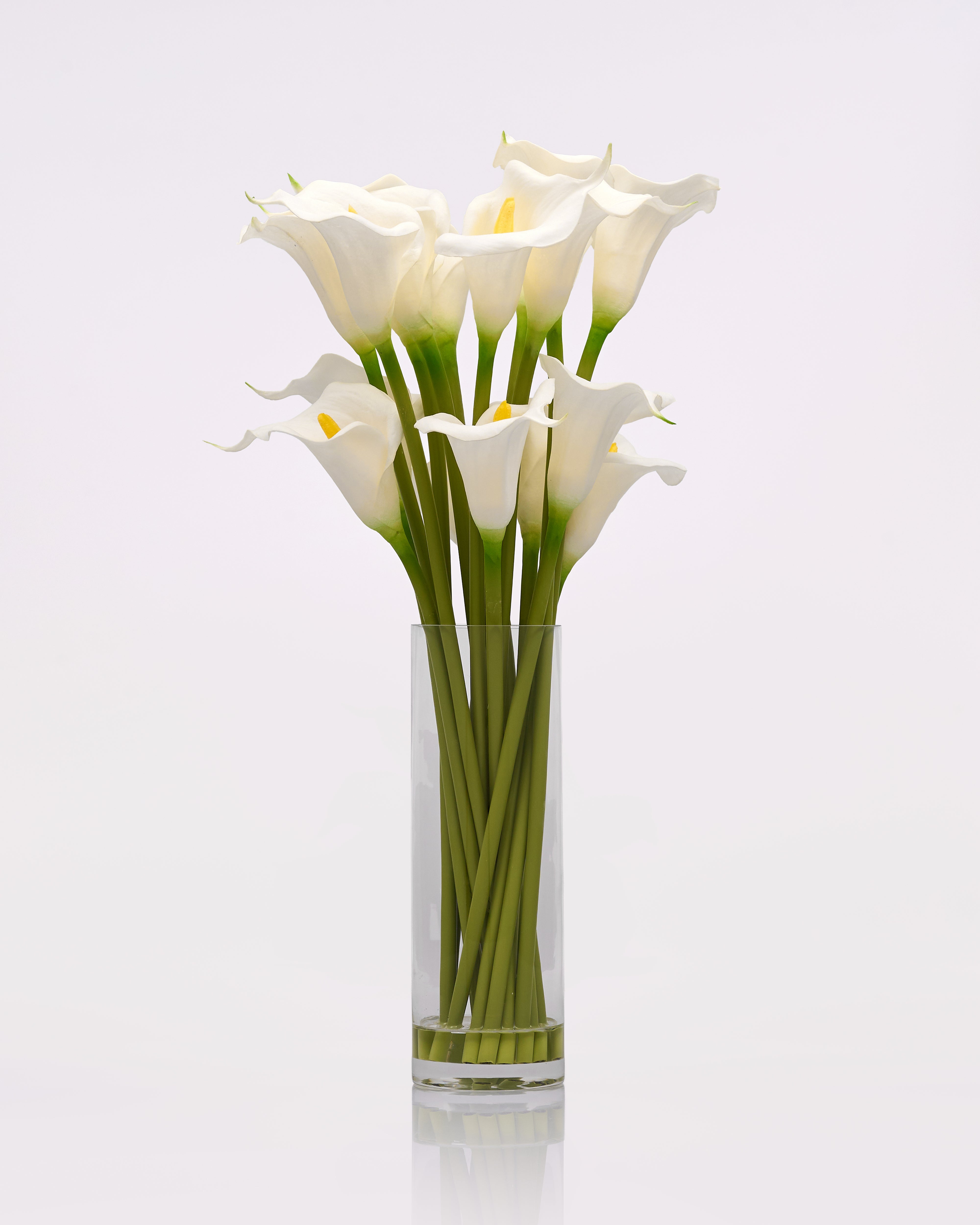Clear glass vase with white calla Ivielle Artificial Flowering Plant on a light gray background