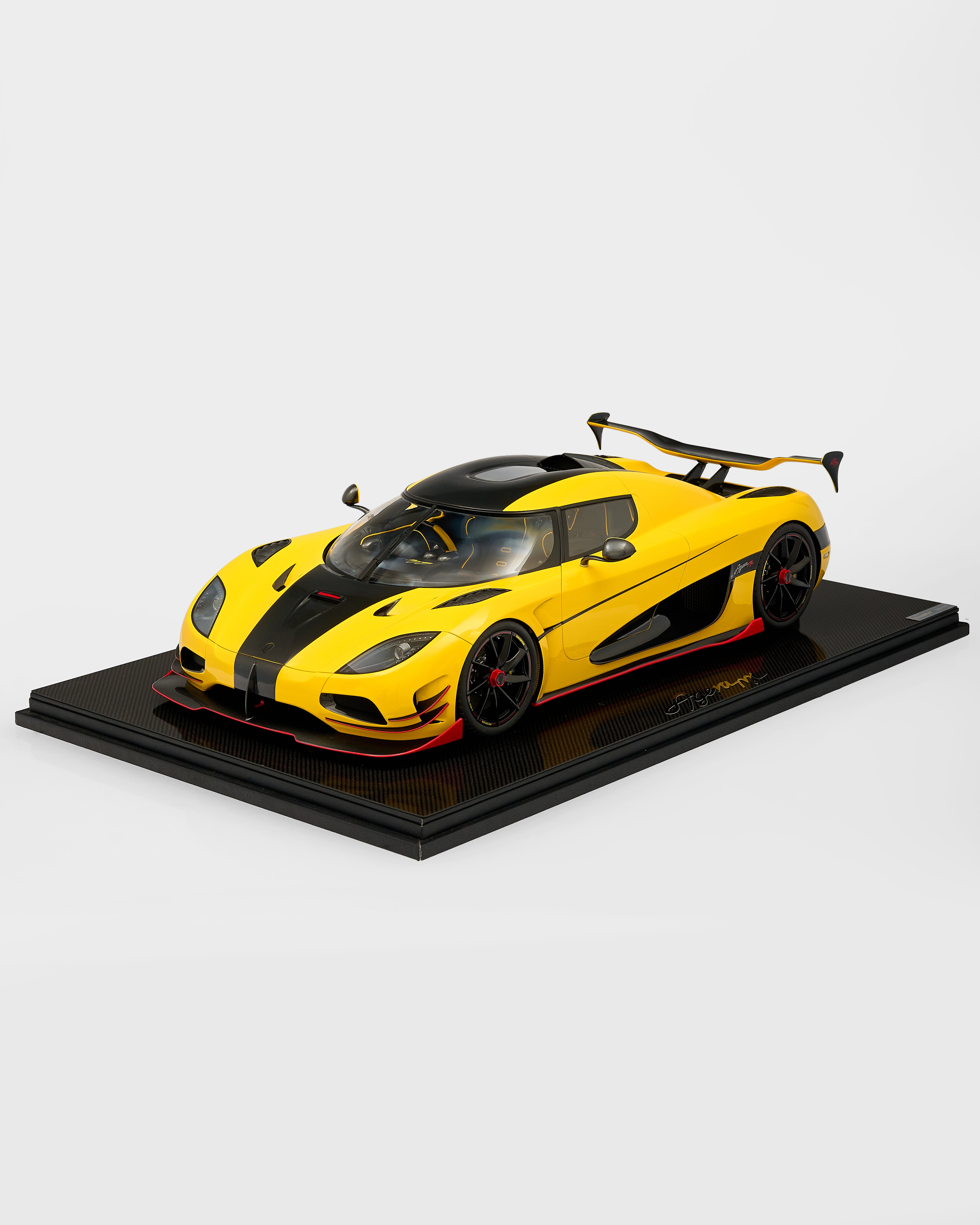 Yellow and black Koenigsegg Agera 1:8 Carbon Model car model on a black platform with a white background