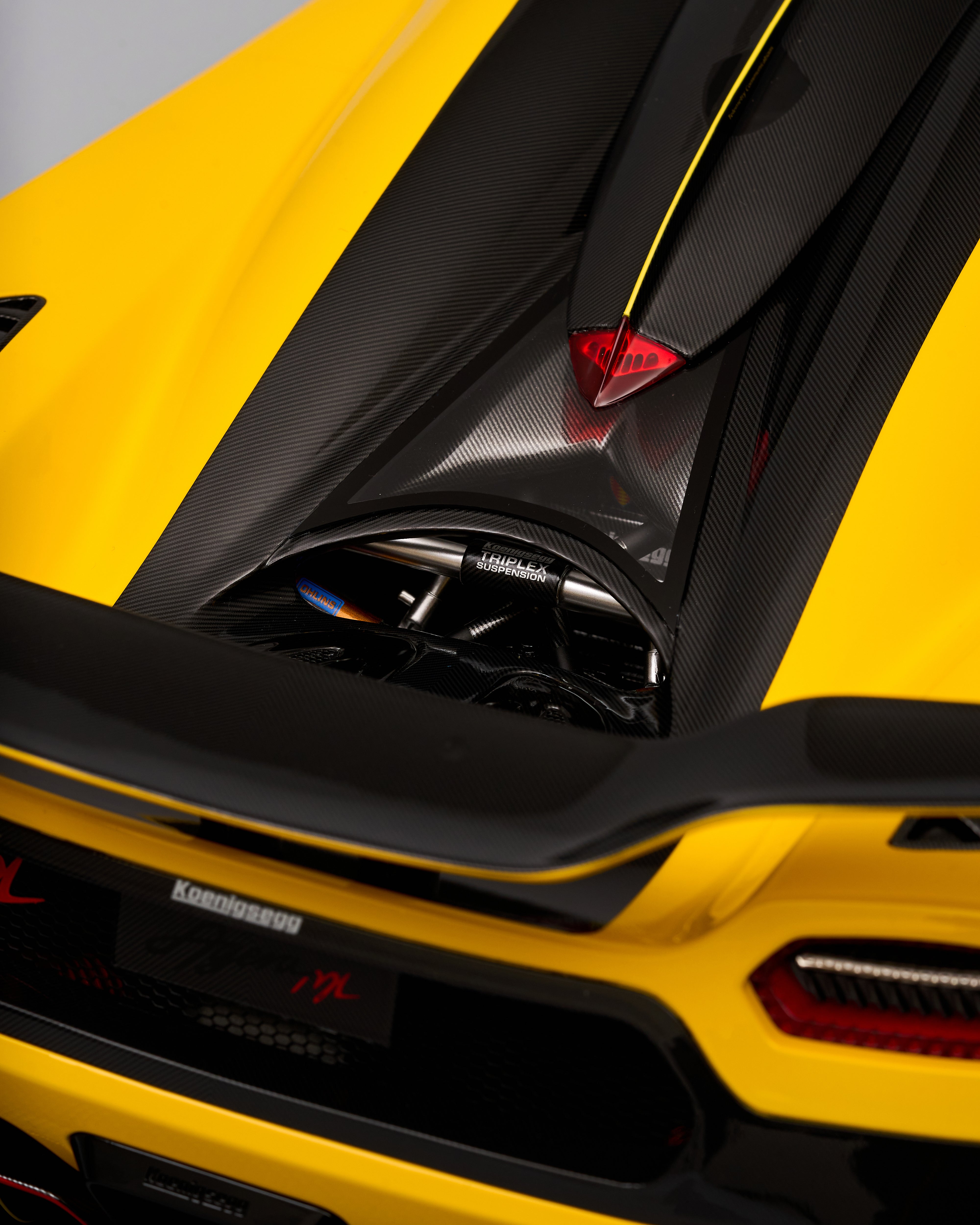 Close-up of a yellow and black sports car with a prominent brand logo.