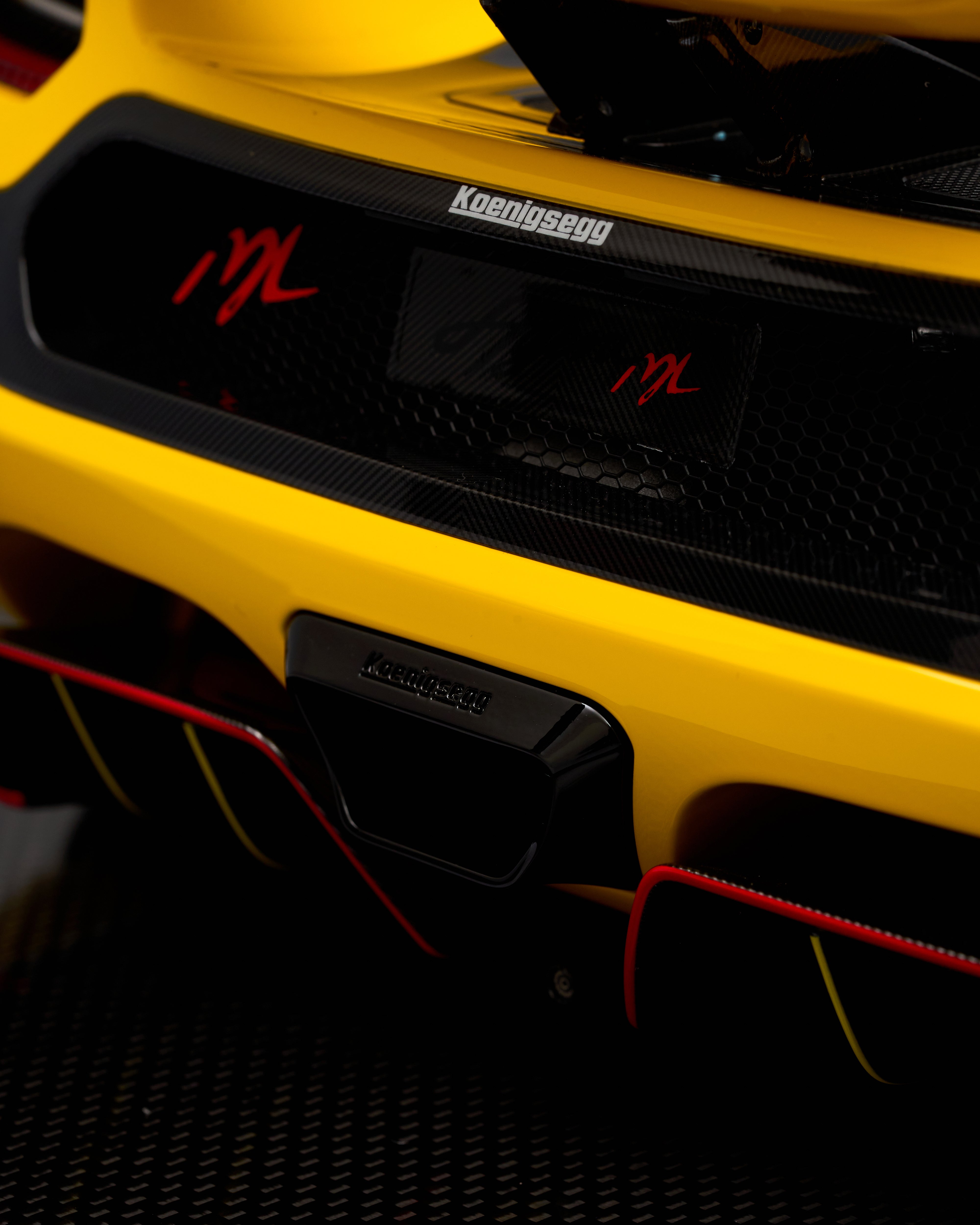 Close-up of a yellow Koenigsegg car with visible branding and design details.