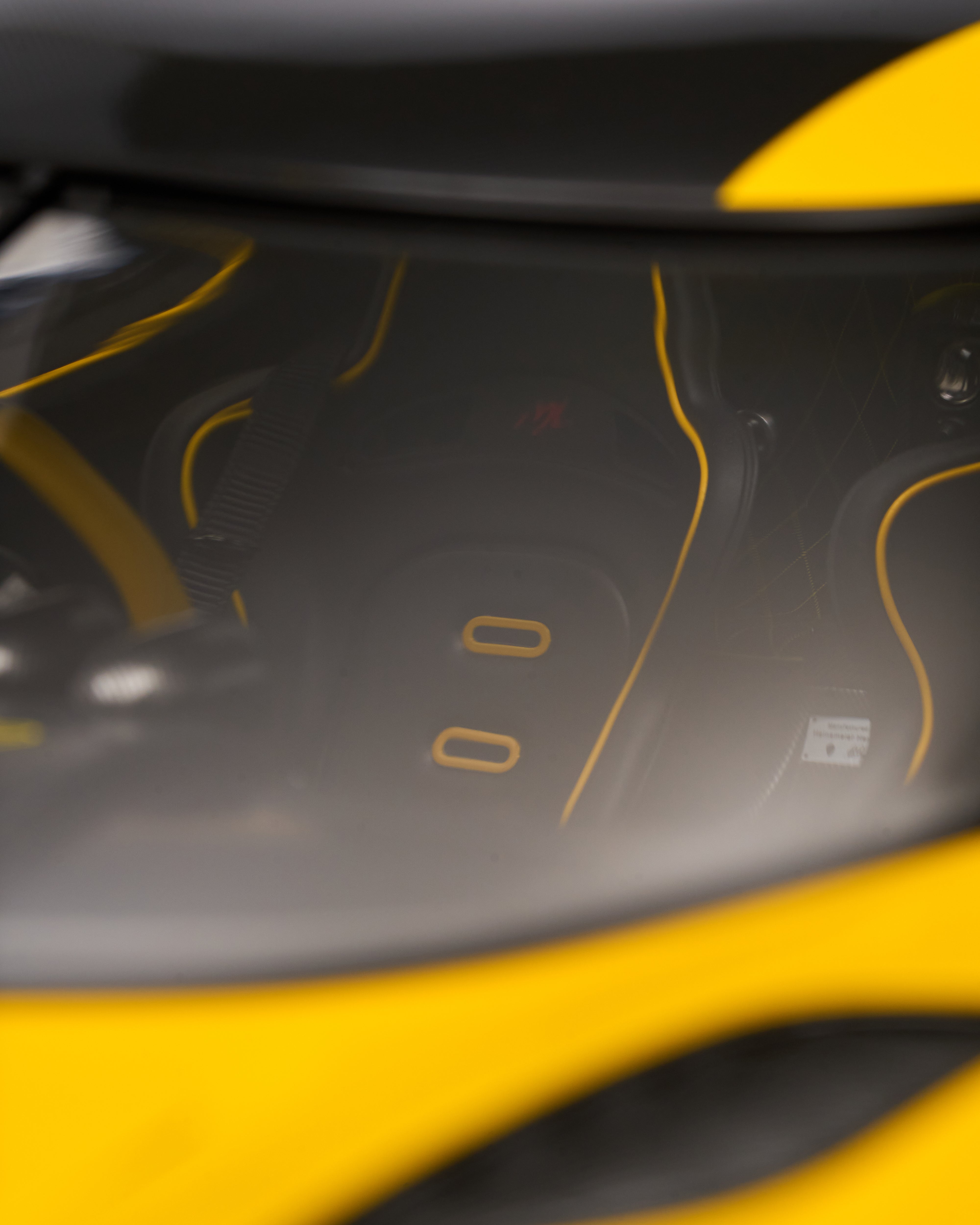 Close-up of a car seat with yellow stitching on a black background