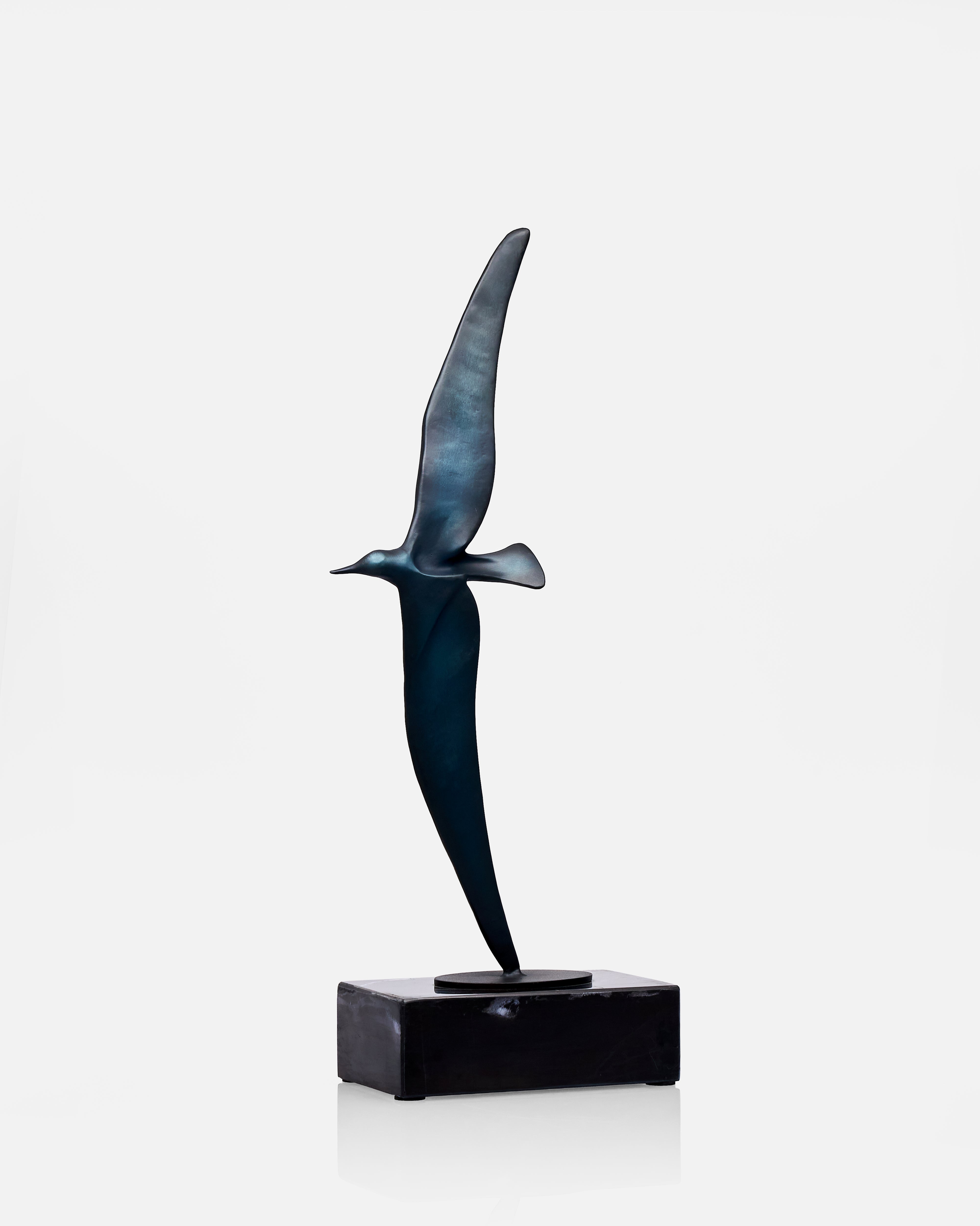 Bronze bird sculpture of a bird in flight on a white background