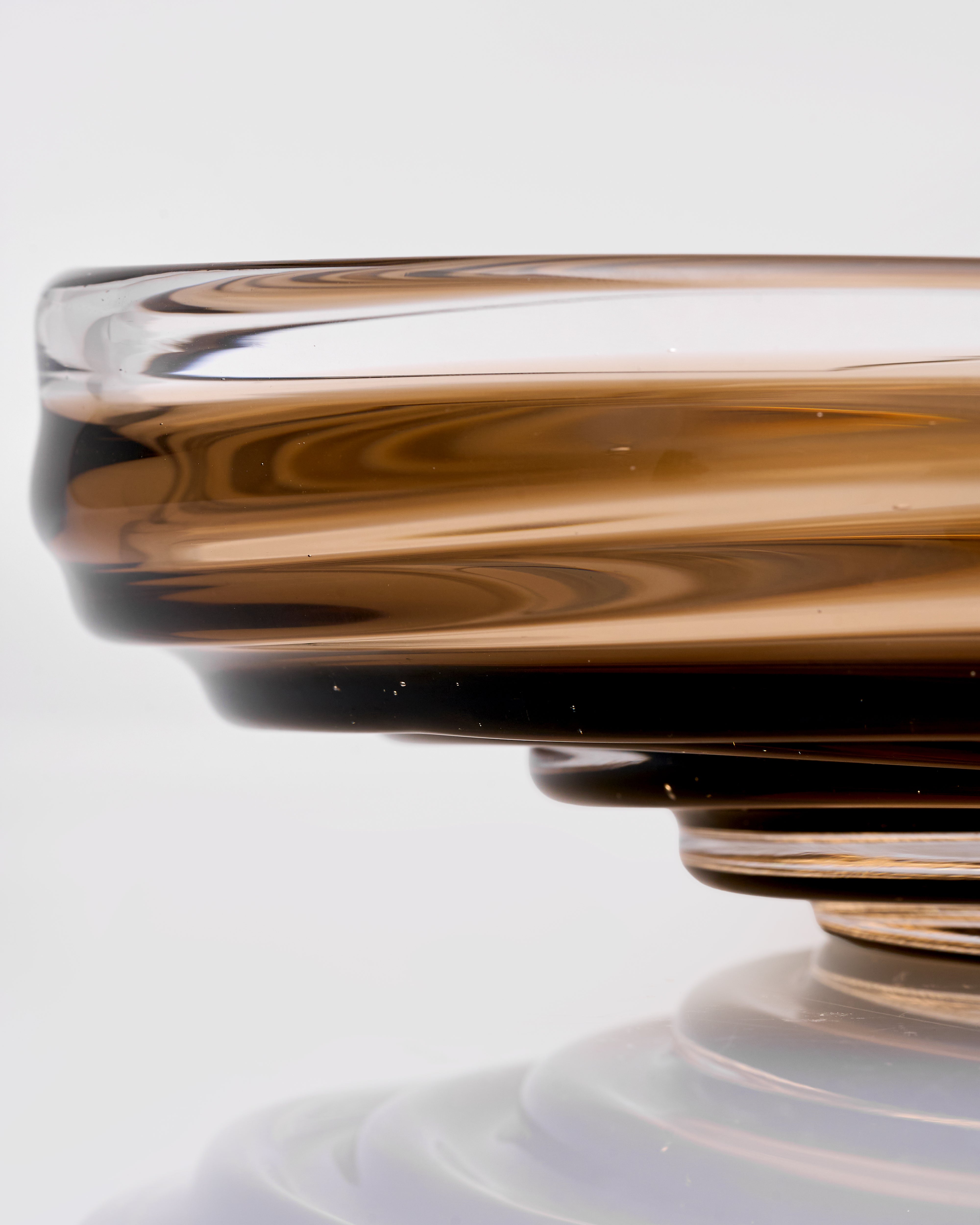 Close-up of a brown glass vase with swirling pattern on a white background