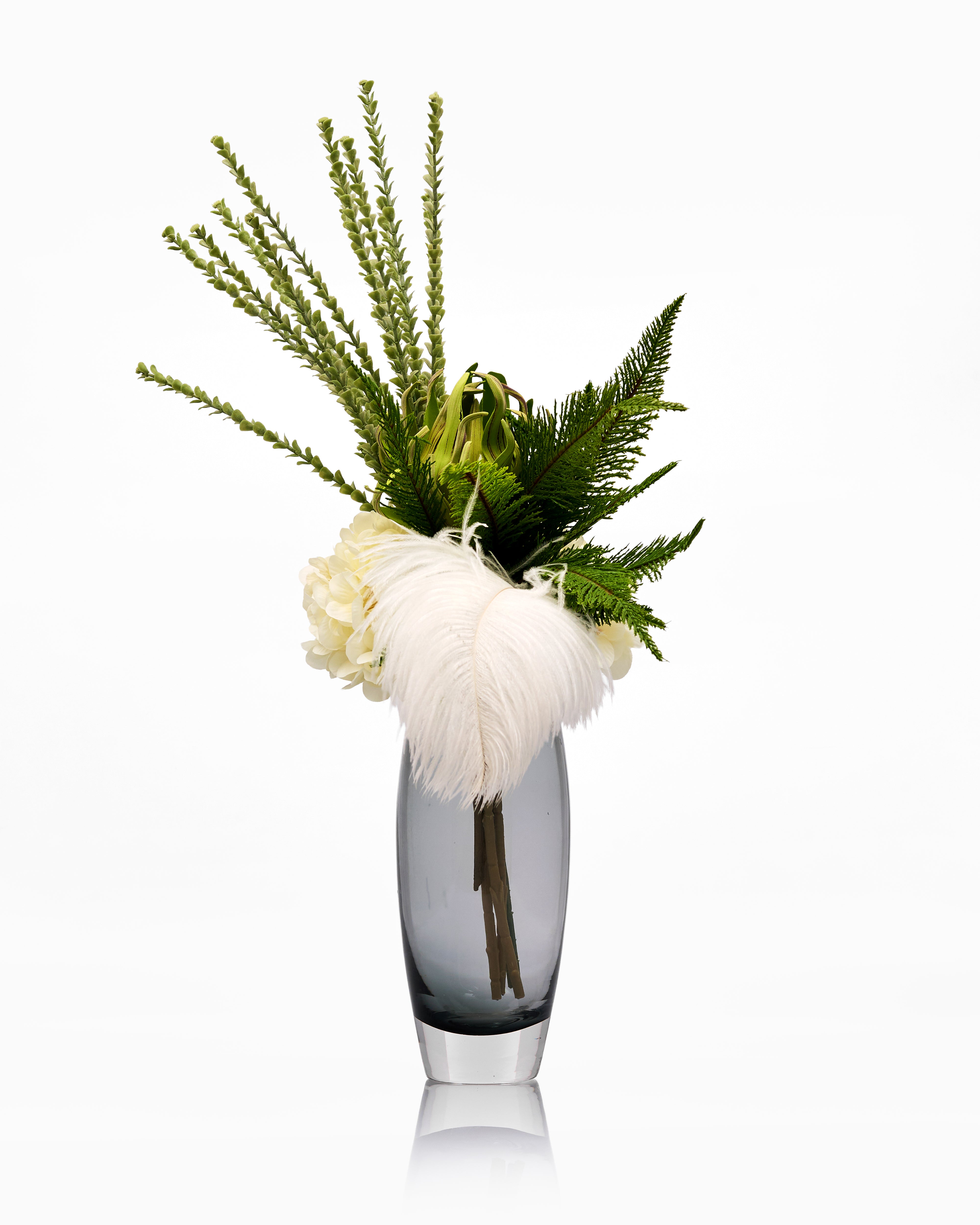 Decorative vase with greenery and feathers on a white background