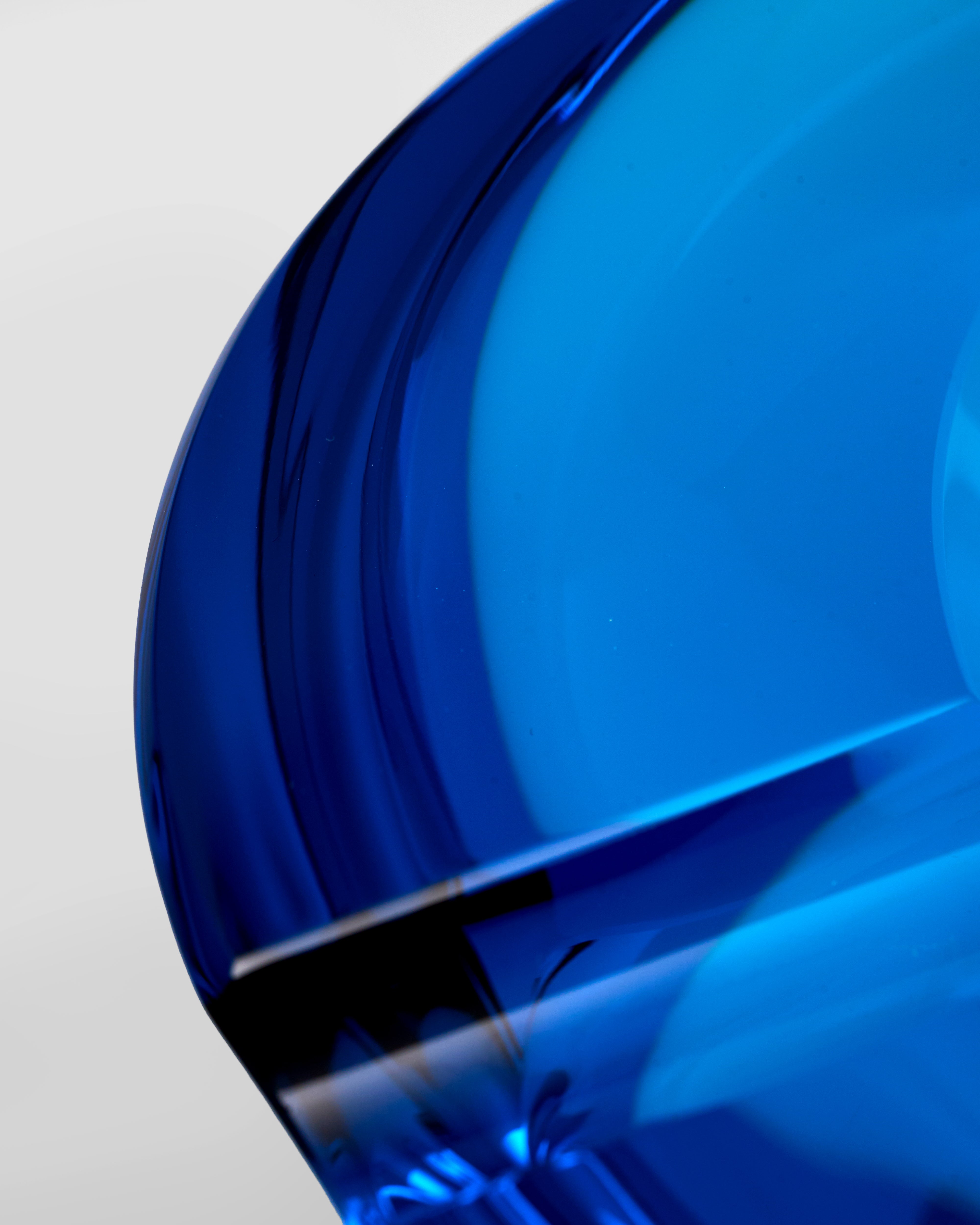 Close-up of a blue glass crystal ashtray object with a reflective surface