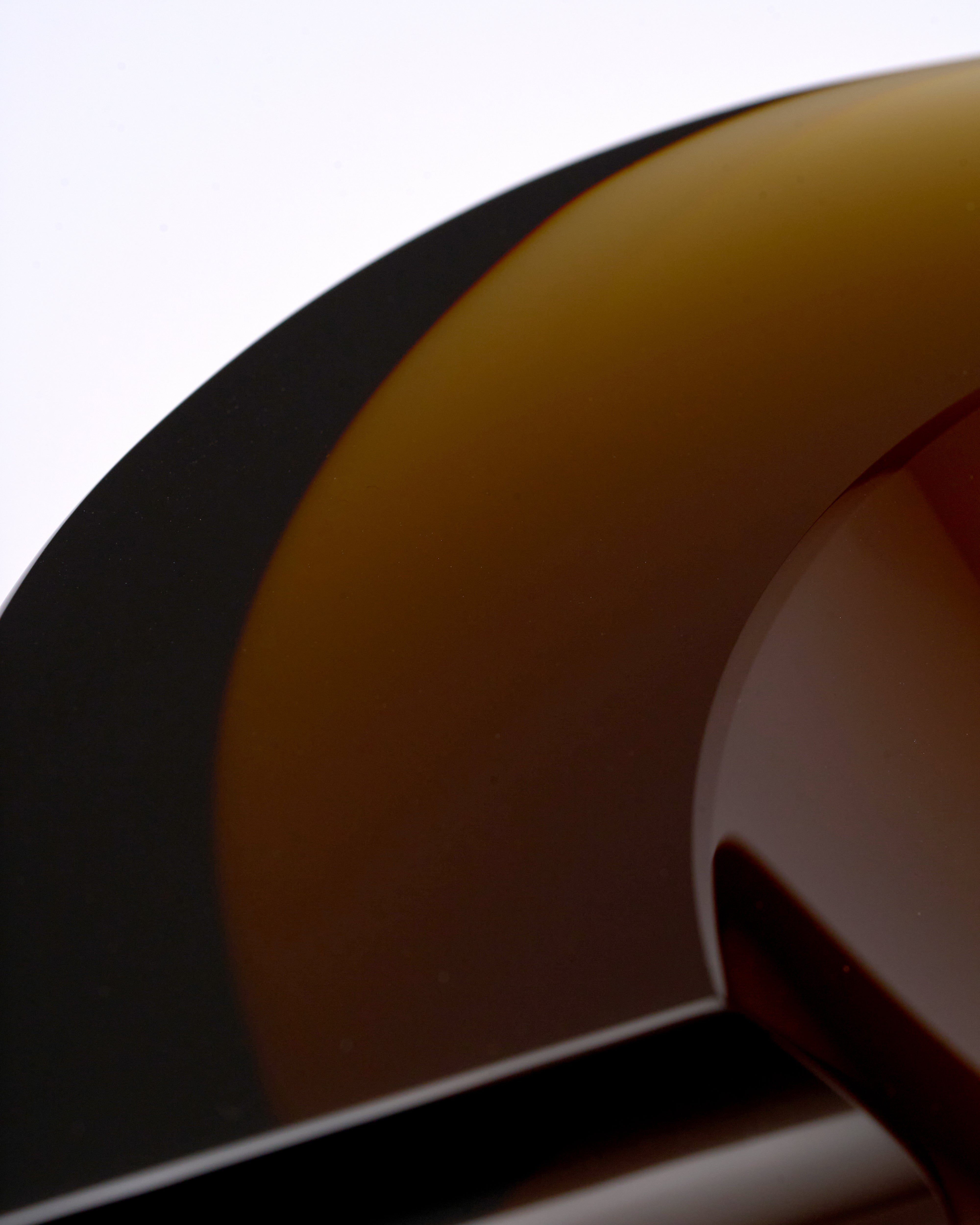 Close-up of a crystal glass ashtray with a focus on the fretboard and headstock.