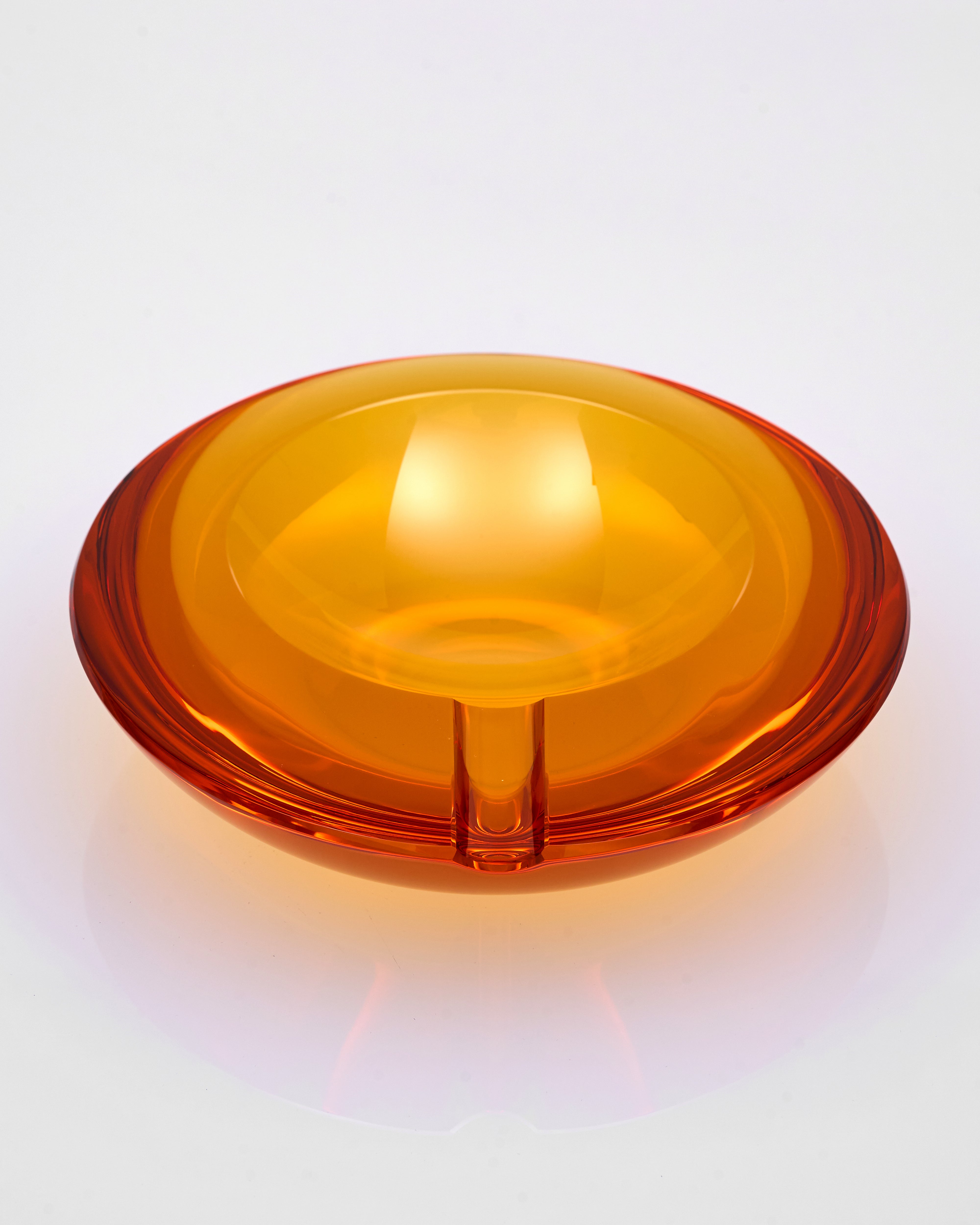 Orange glass ash tray on a white background
