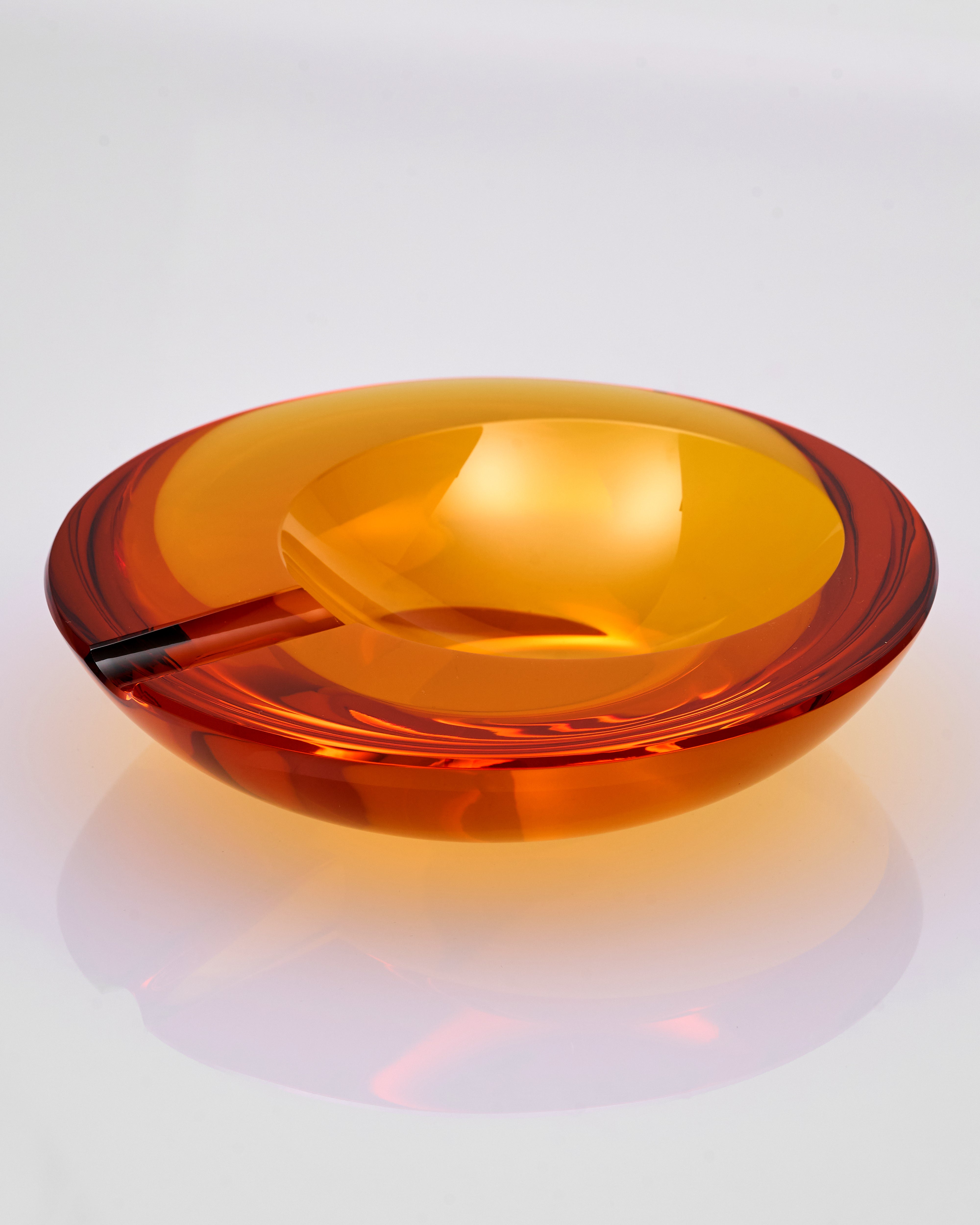 Amber-colored glass ashtray on a white background