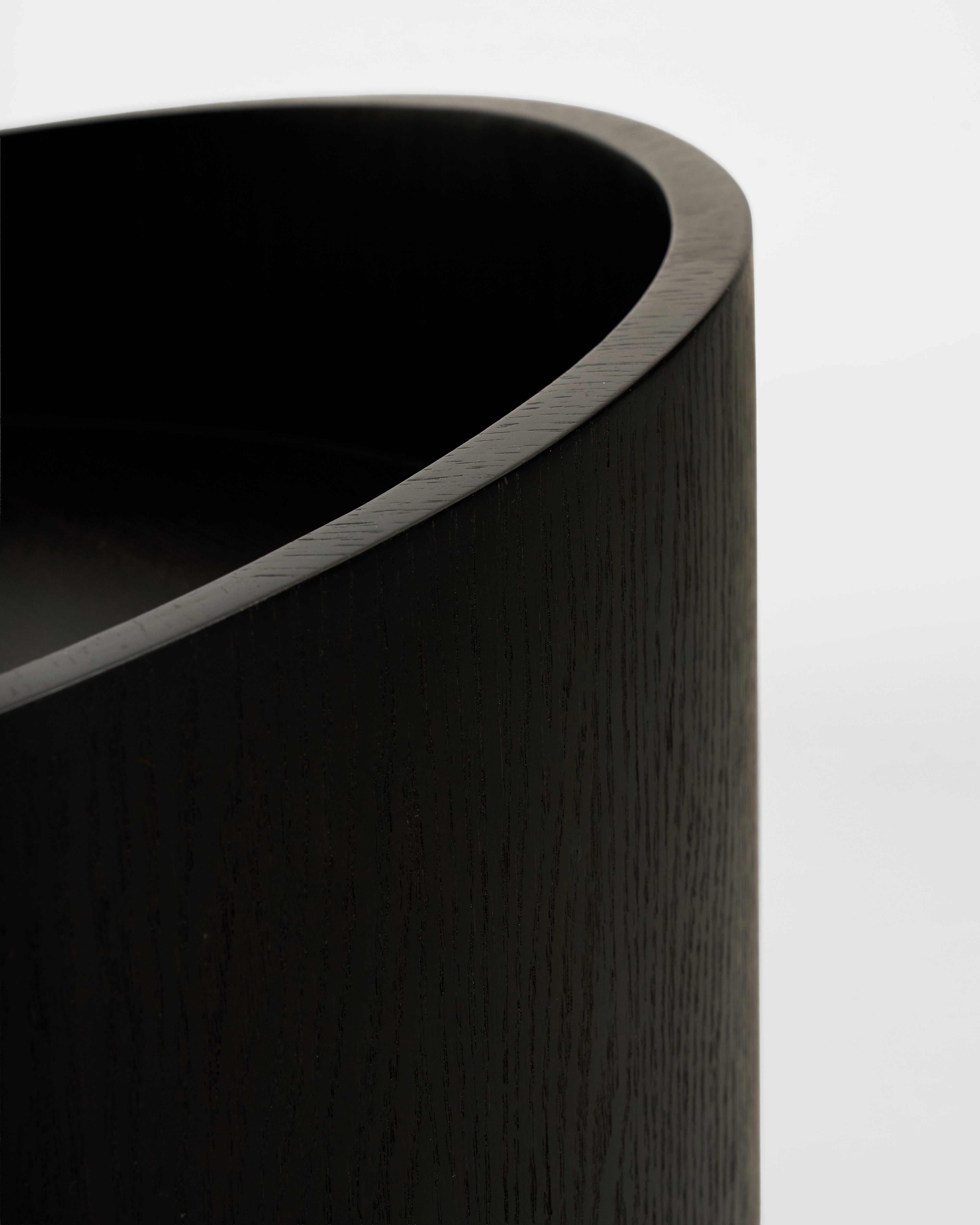 Close-up of a dark wooden cylindrical object with a light gray interior.