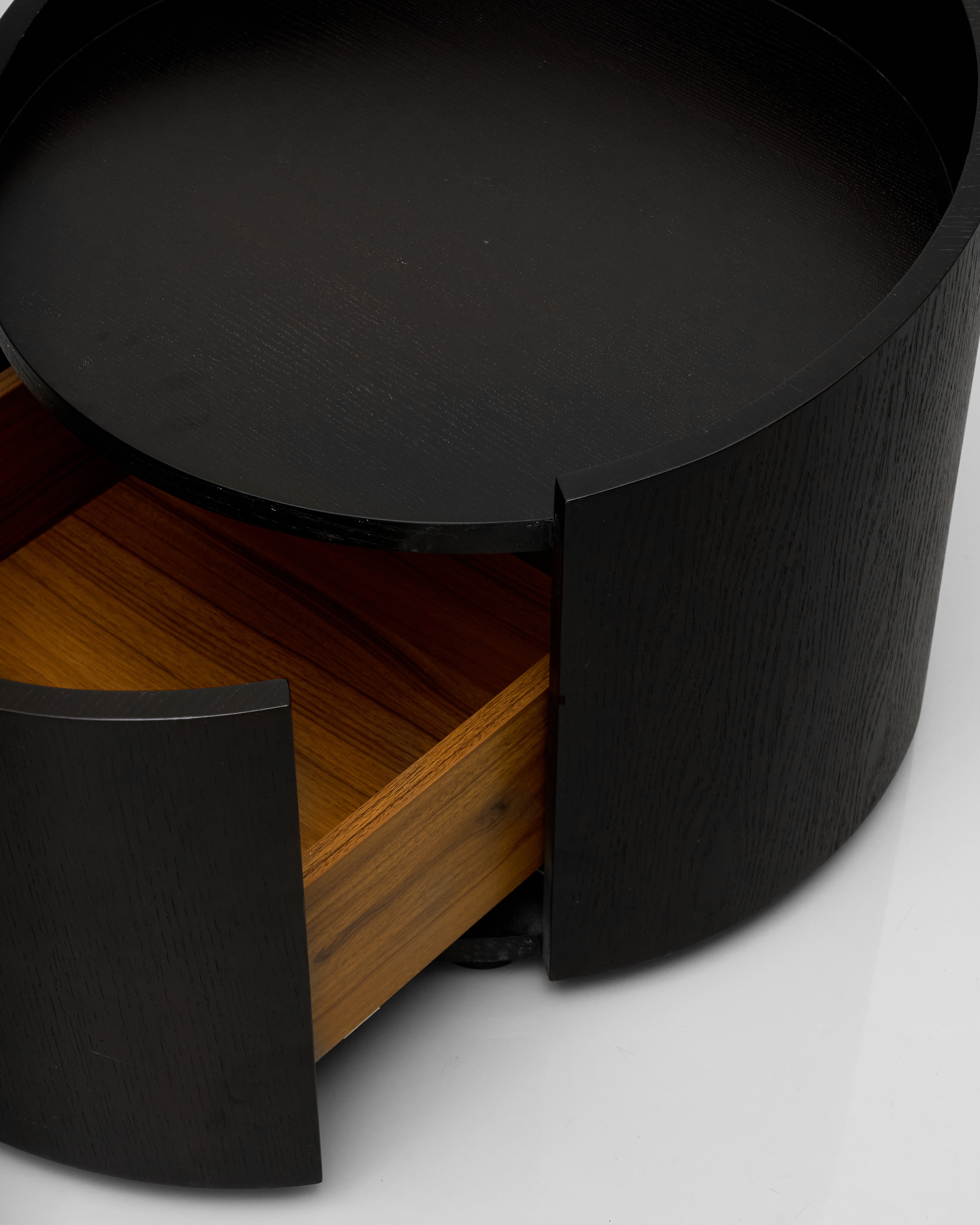 Close-up of a black cylindrical object with a wooden base on a white background