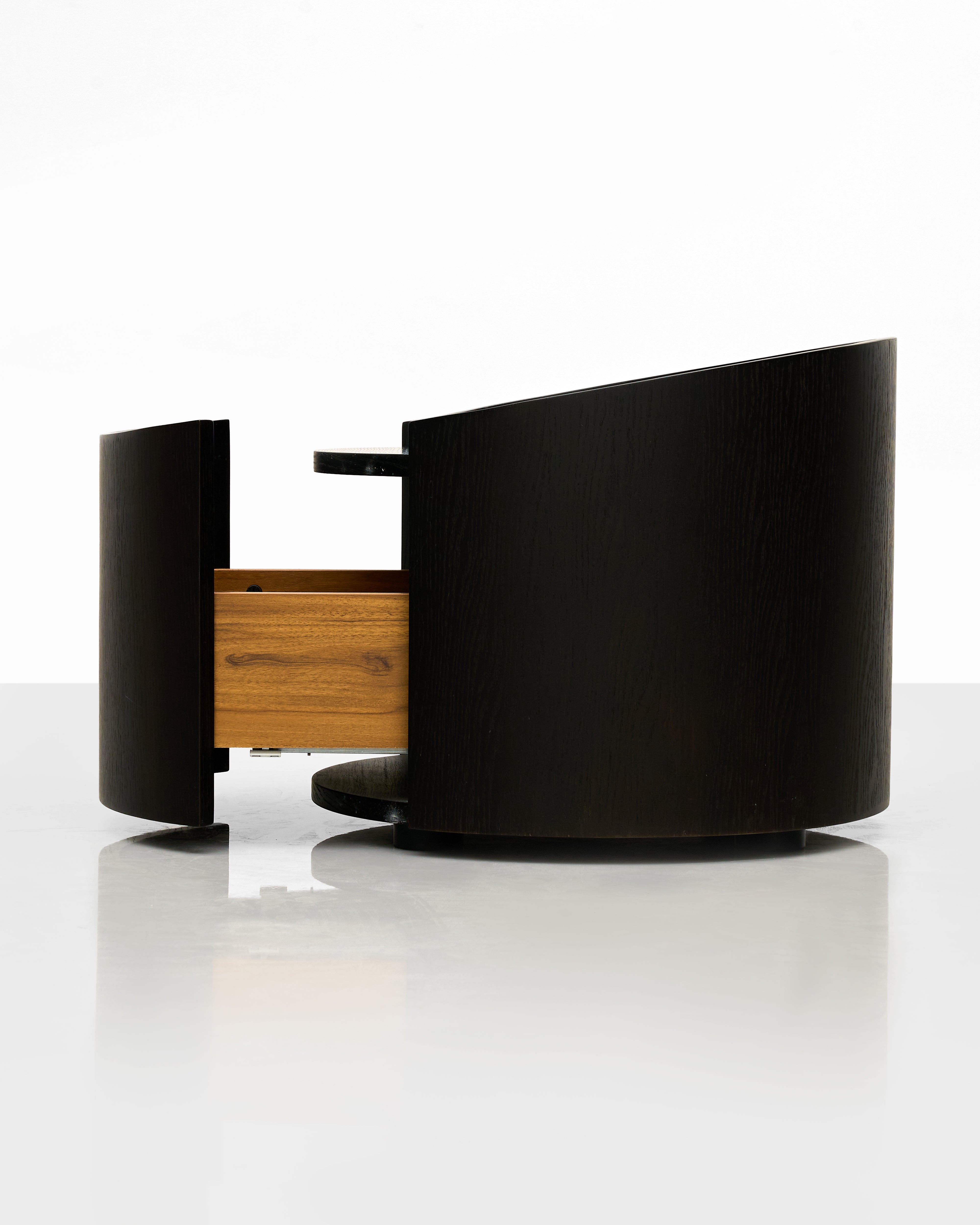 Modern black round side table with wooden drawer on a white background