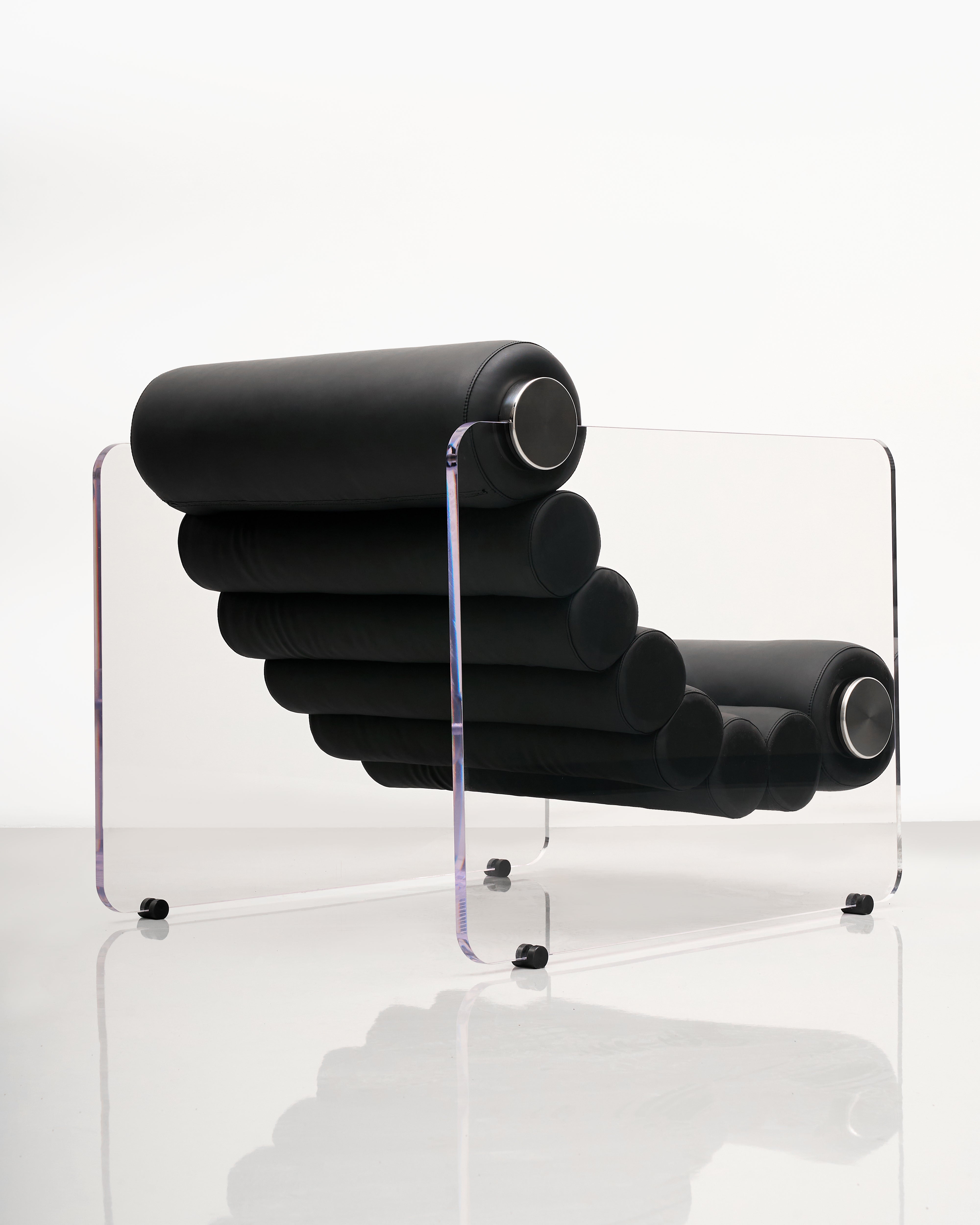 Modern black lounge chair with clear acrylic base on a white background