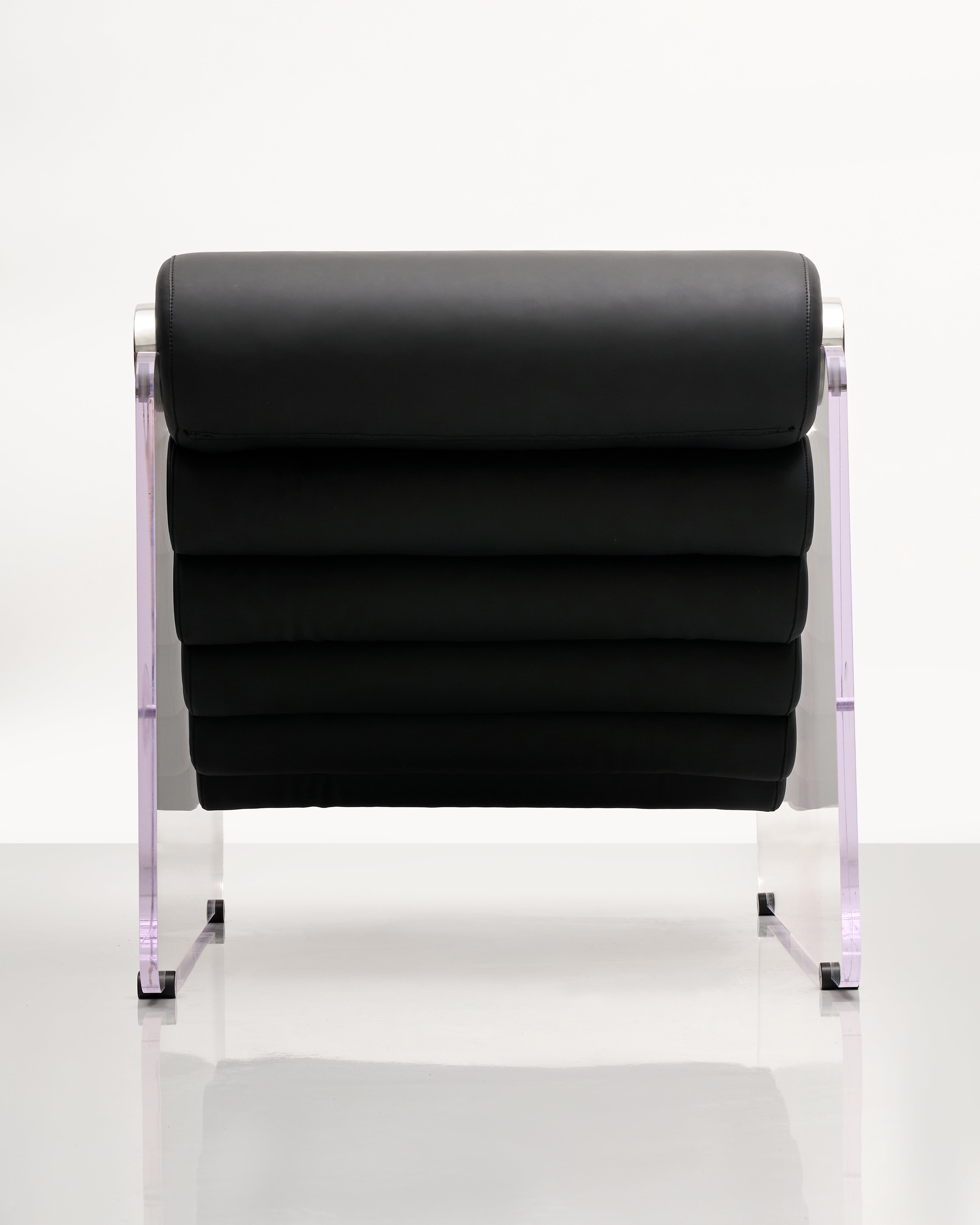 Black lounge chair with transparent acrylic side legs on a white background