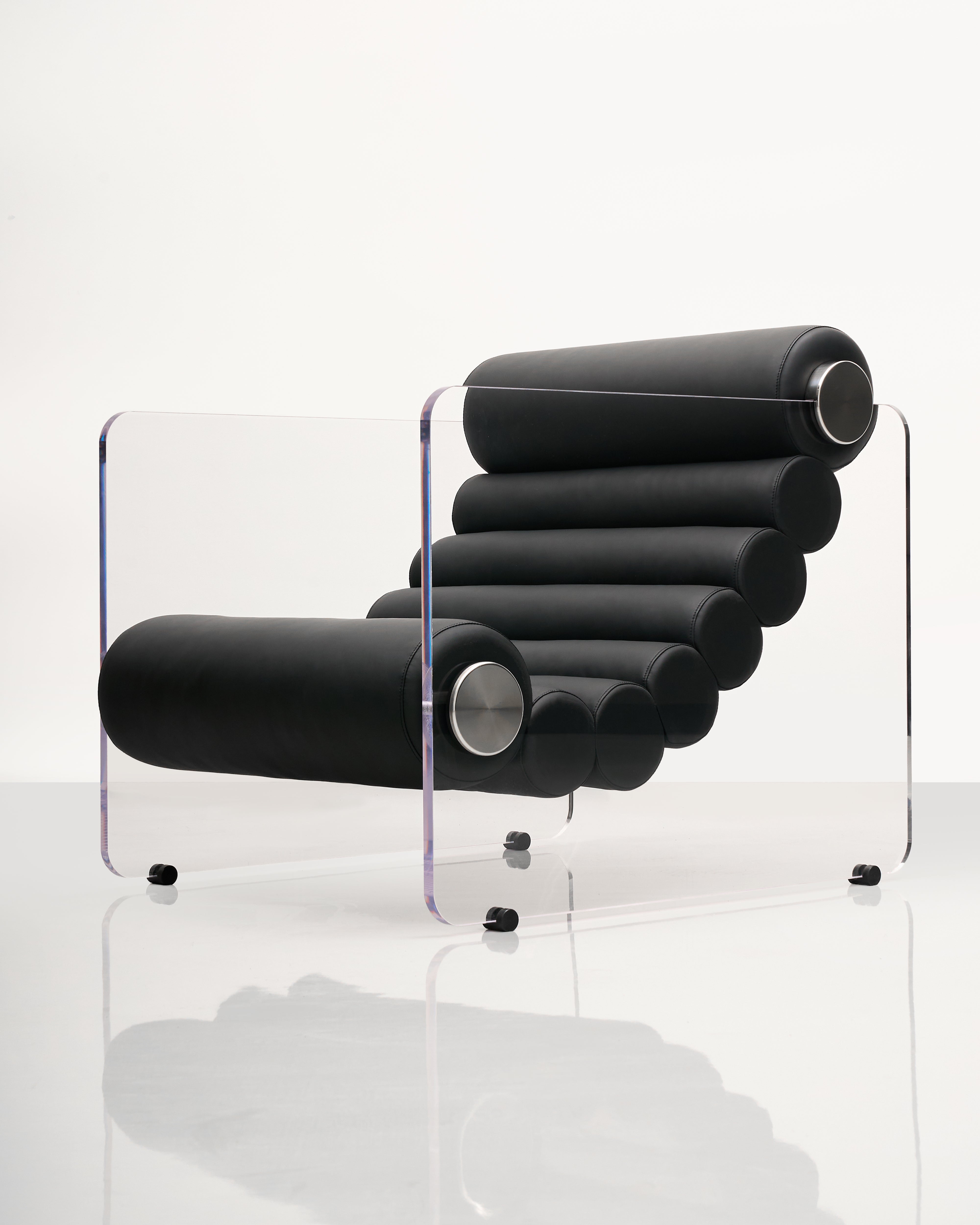 Modern black lounge chair with clear acrylic legs on a white background