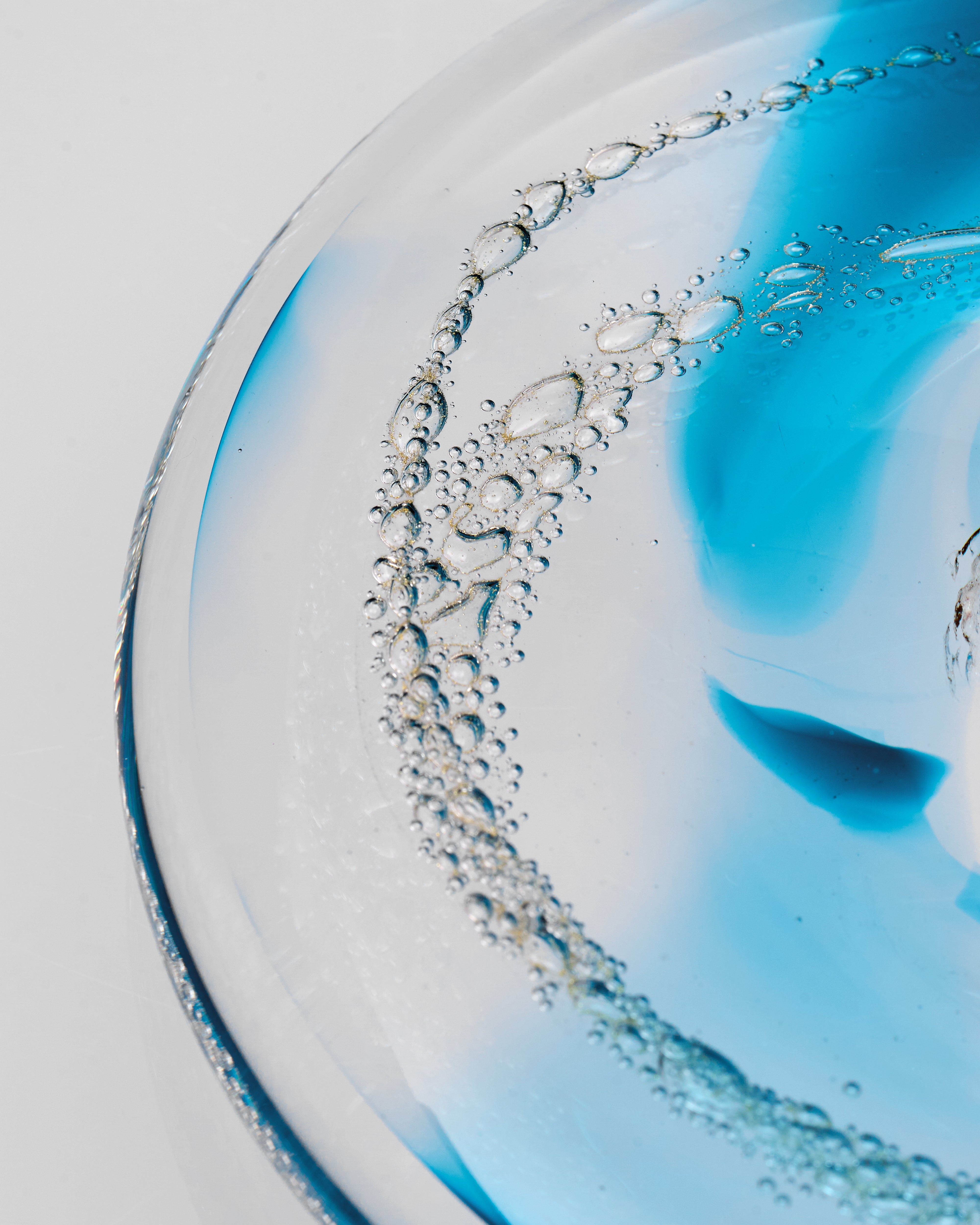 Close-up of a crystal glass decor with water droplets design on a light blue and white background