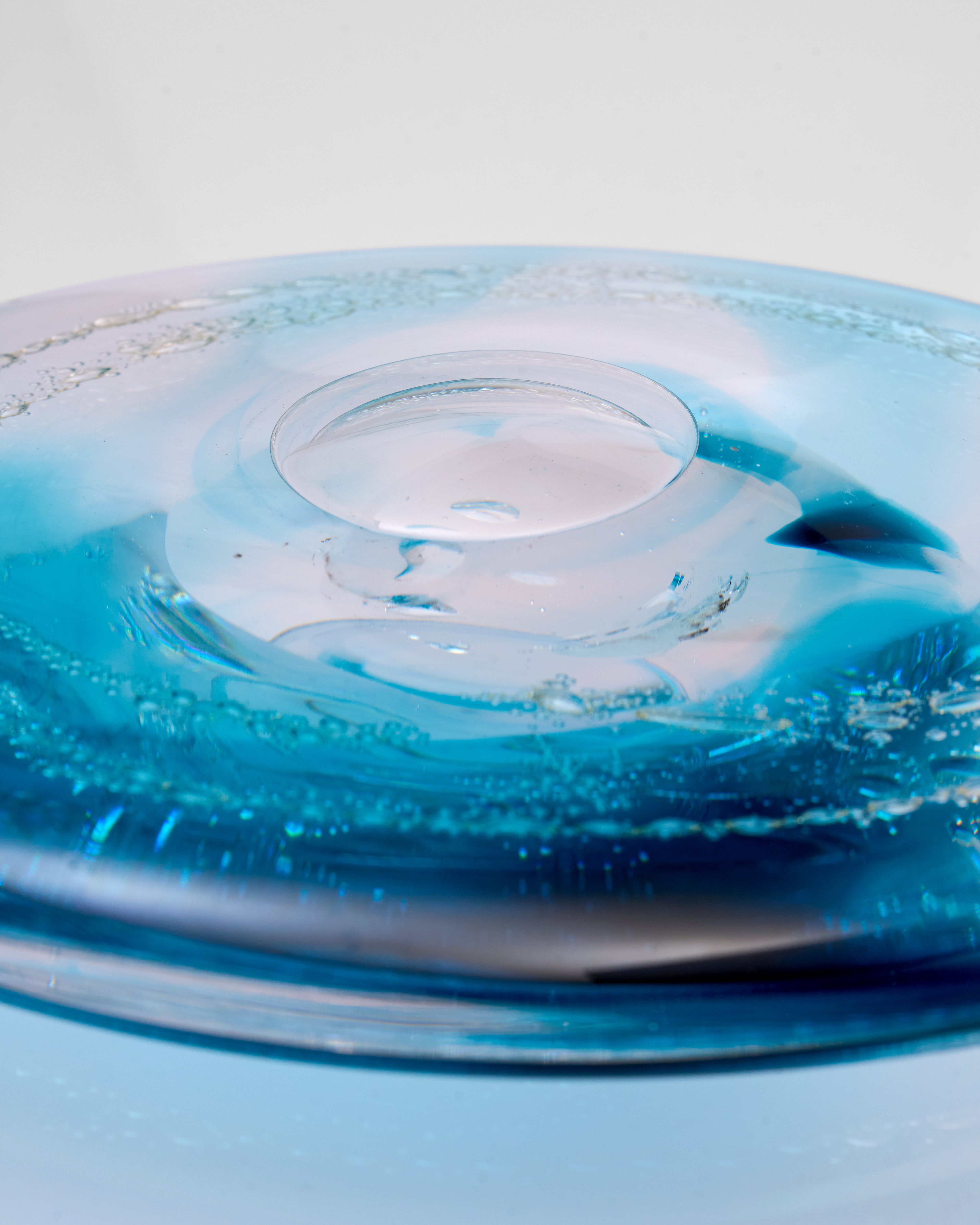 Close-up of a blue glass  decor with water droplets design on a light gray background