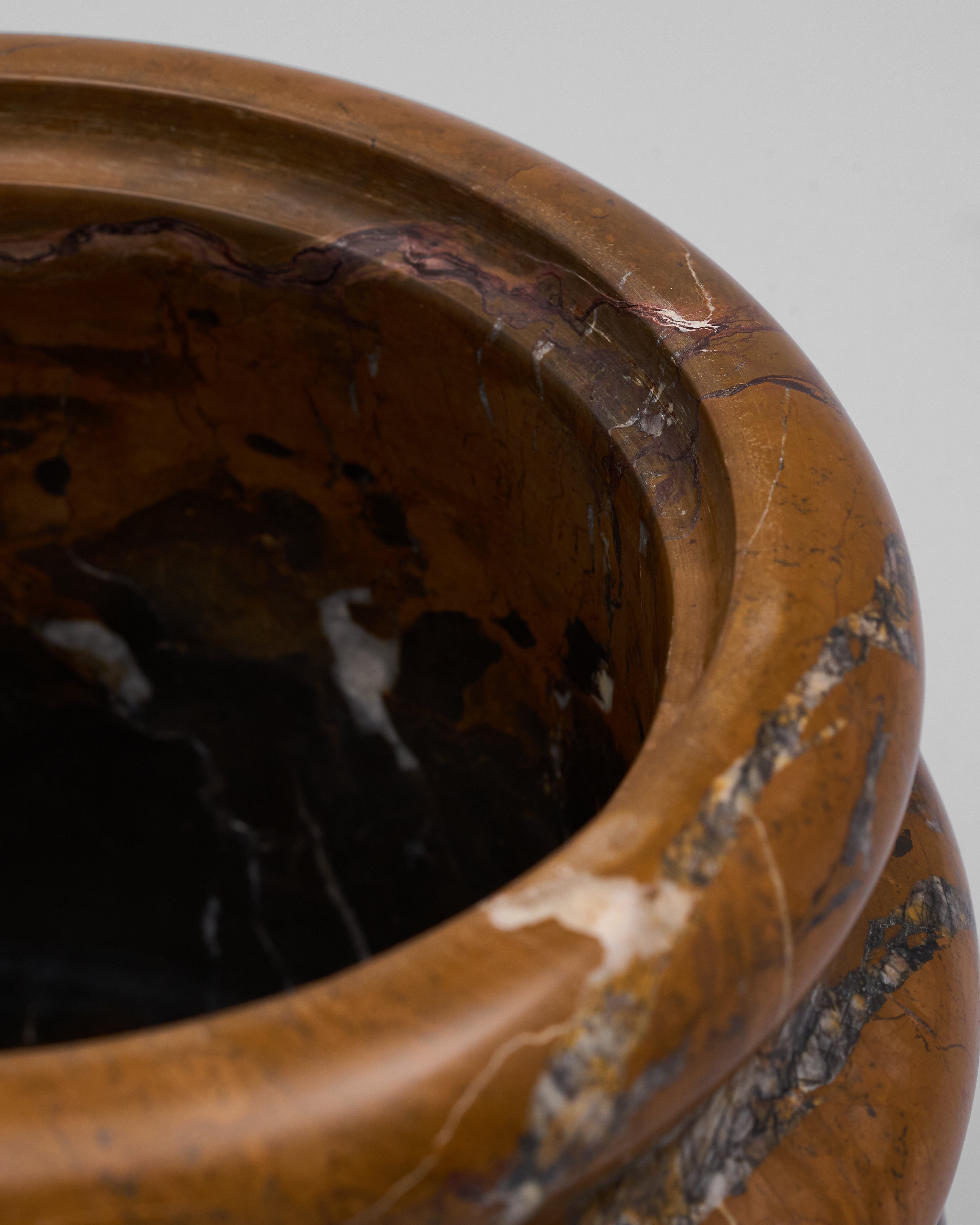 Close-up of a brown marble pot with marbled design on a gray background