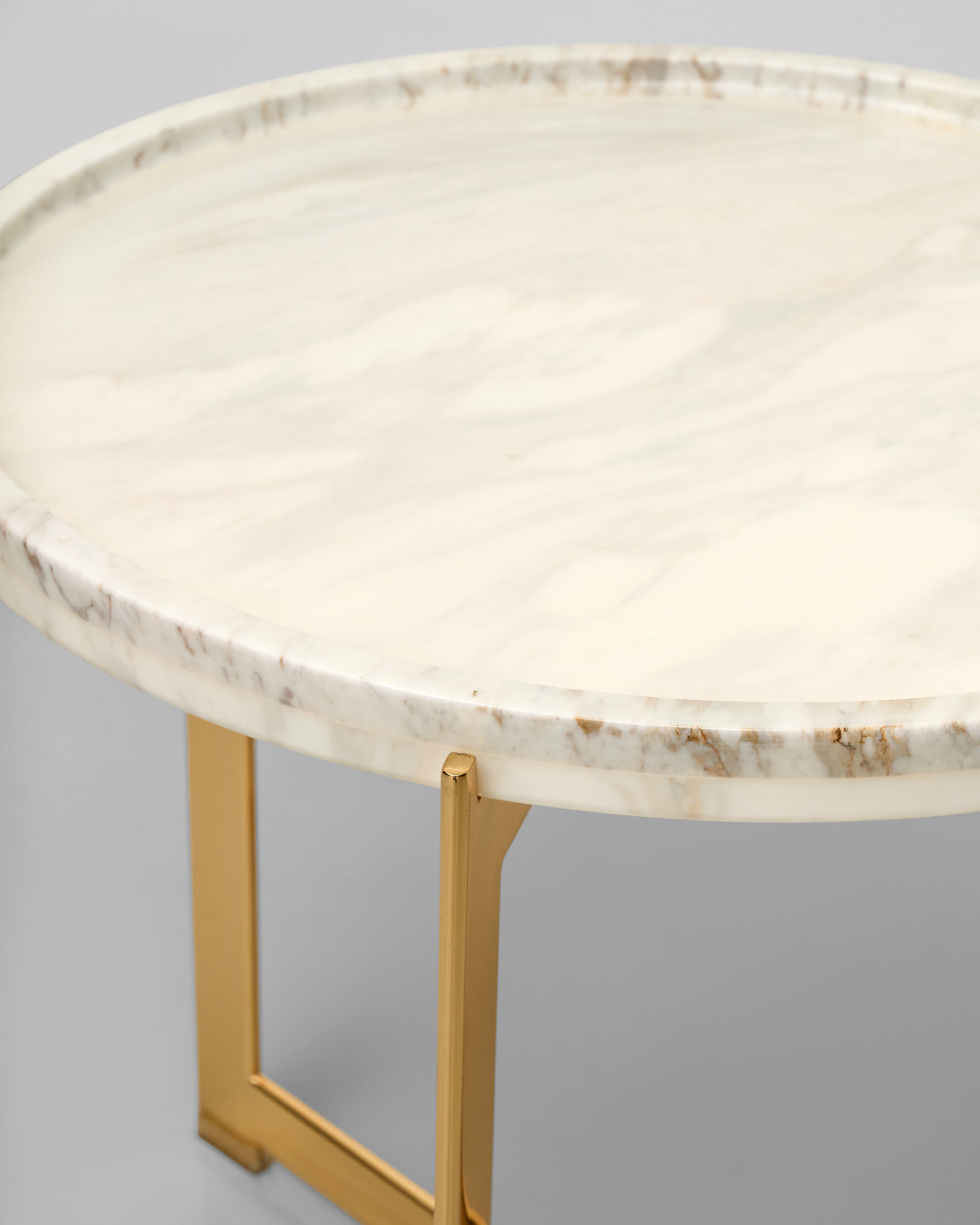 Round marble table with gold legs on a gray background