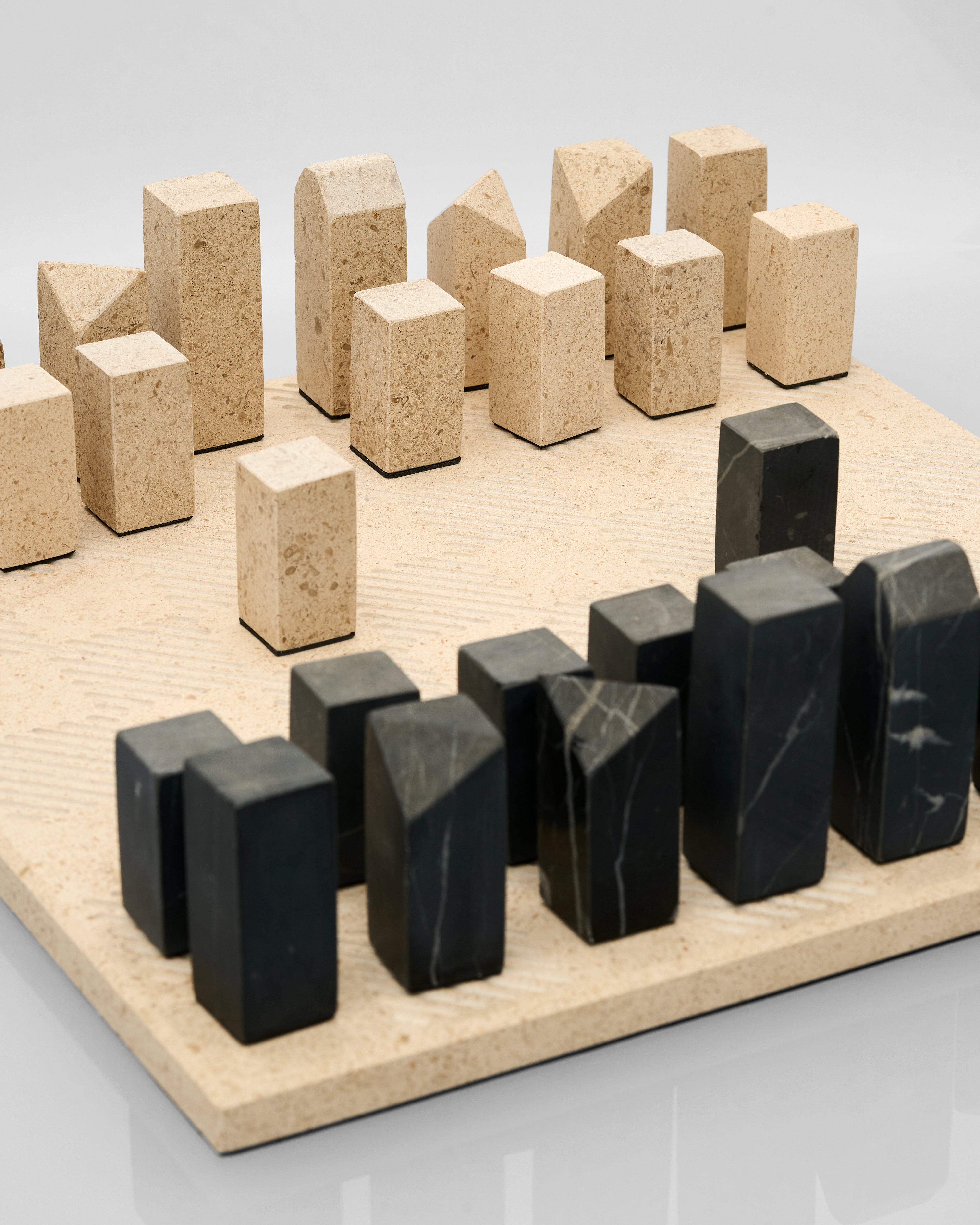 Ivory and black marble geometric blocks on a light gray background