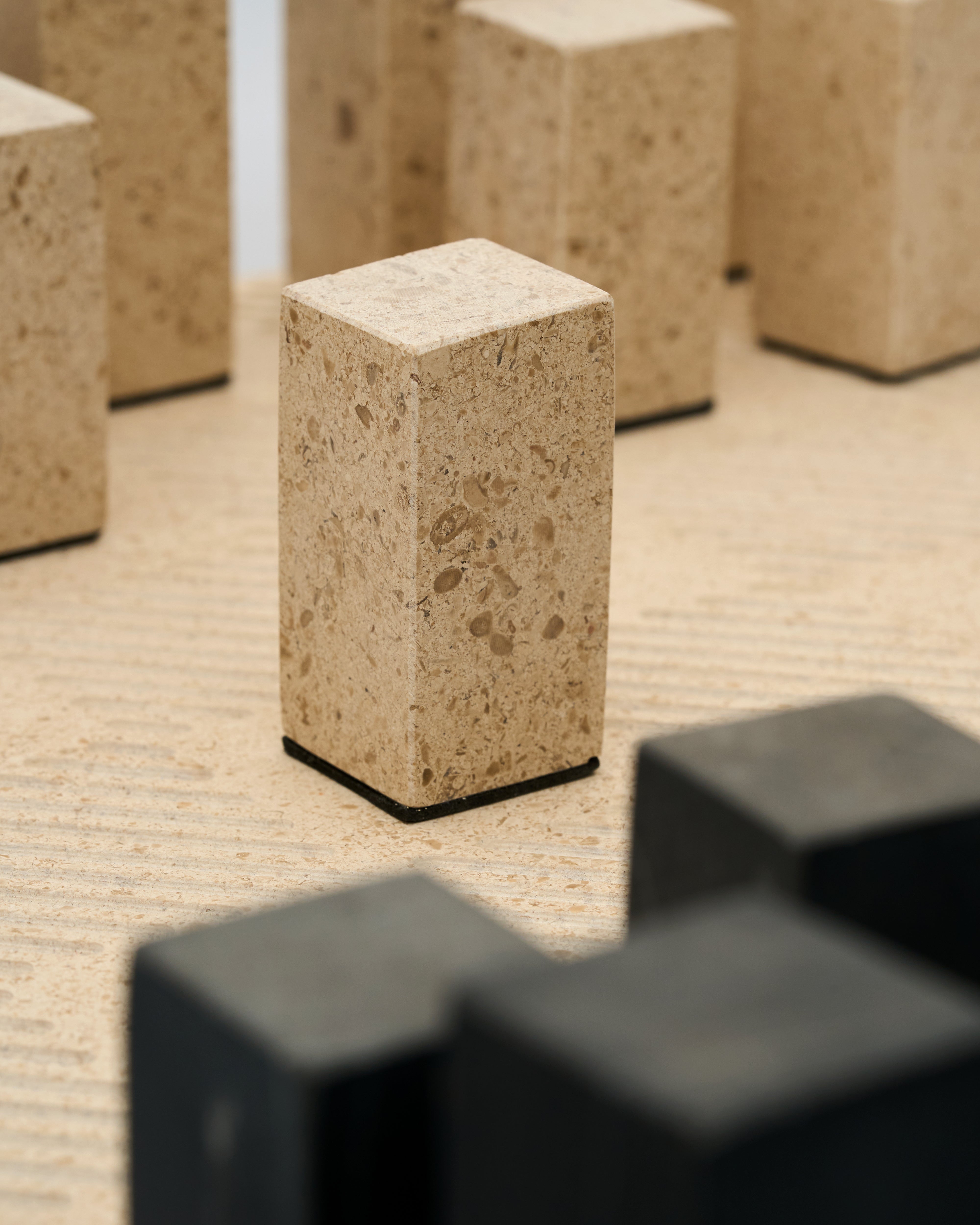 Close-up of textured stone blocks of marble chess board with a blurred foreground