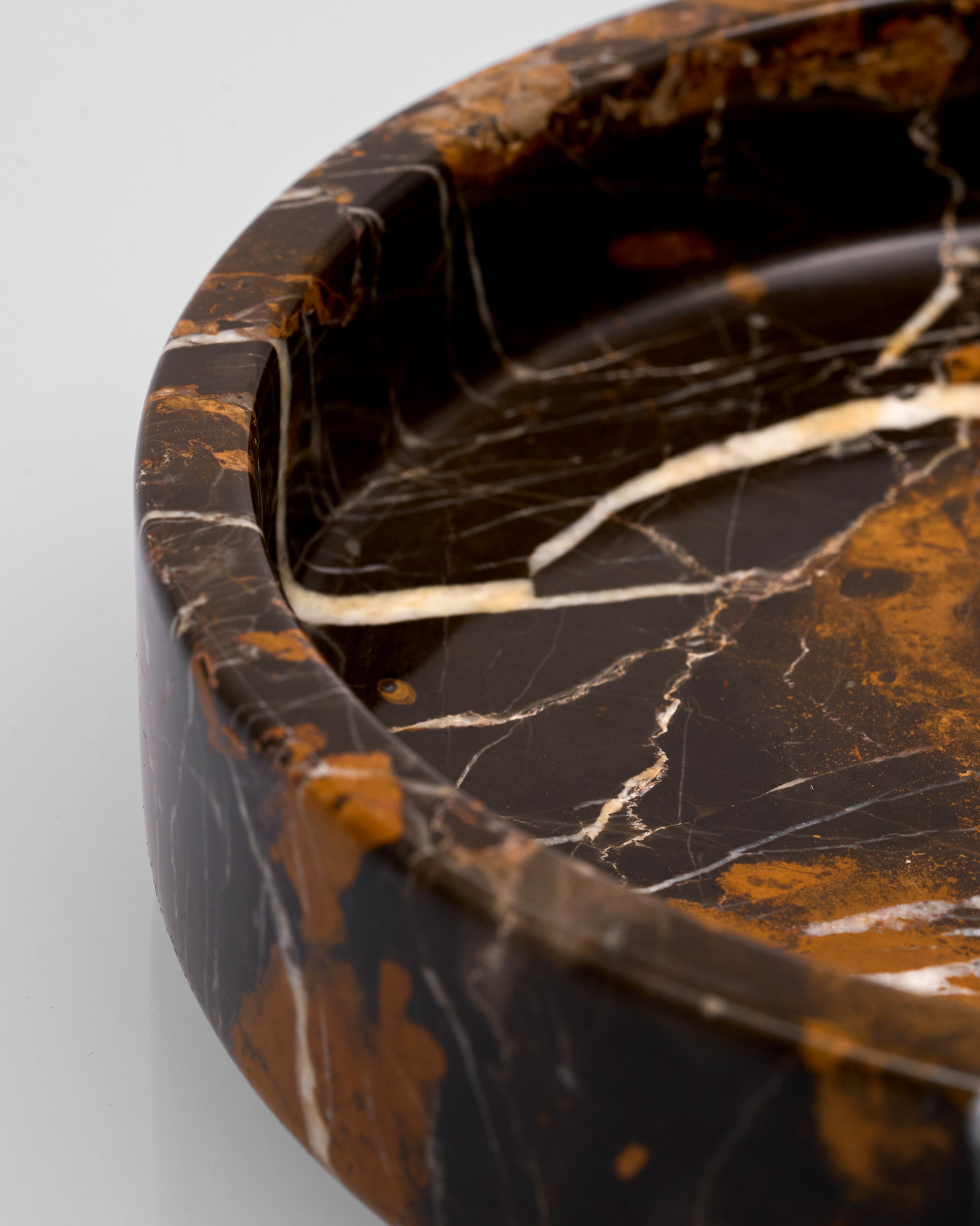 Close-up of a marbled stone tray with brown and black patterns on a light gray background