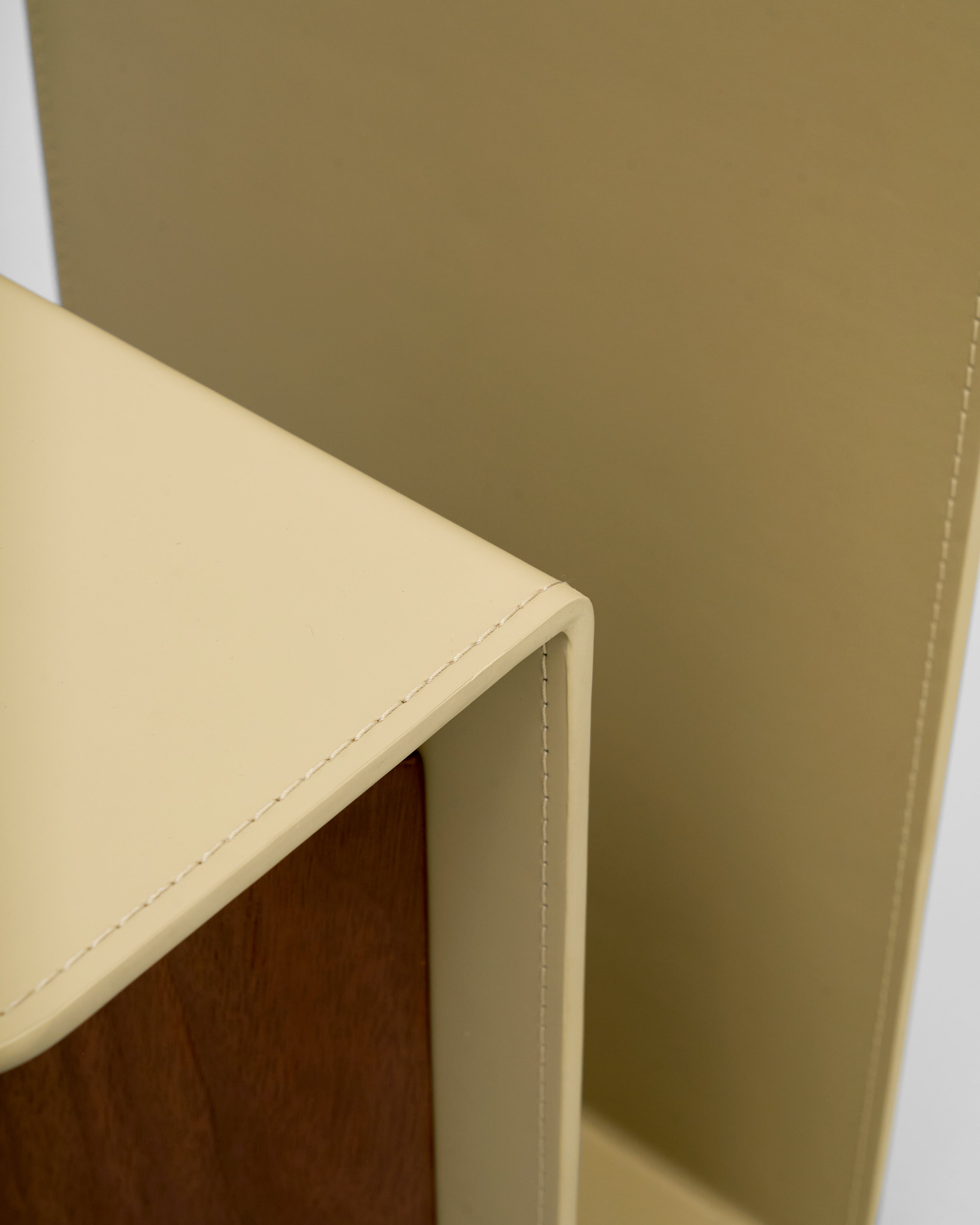 Close-up of a corner where beige leather meets brown wood.