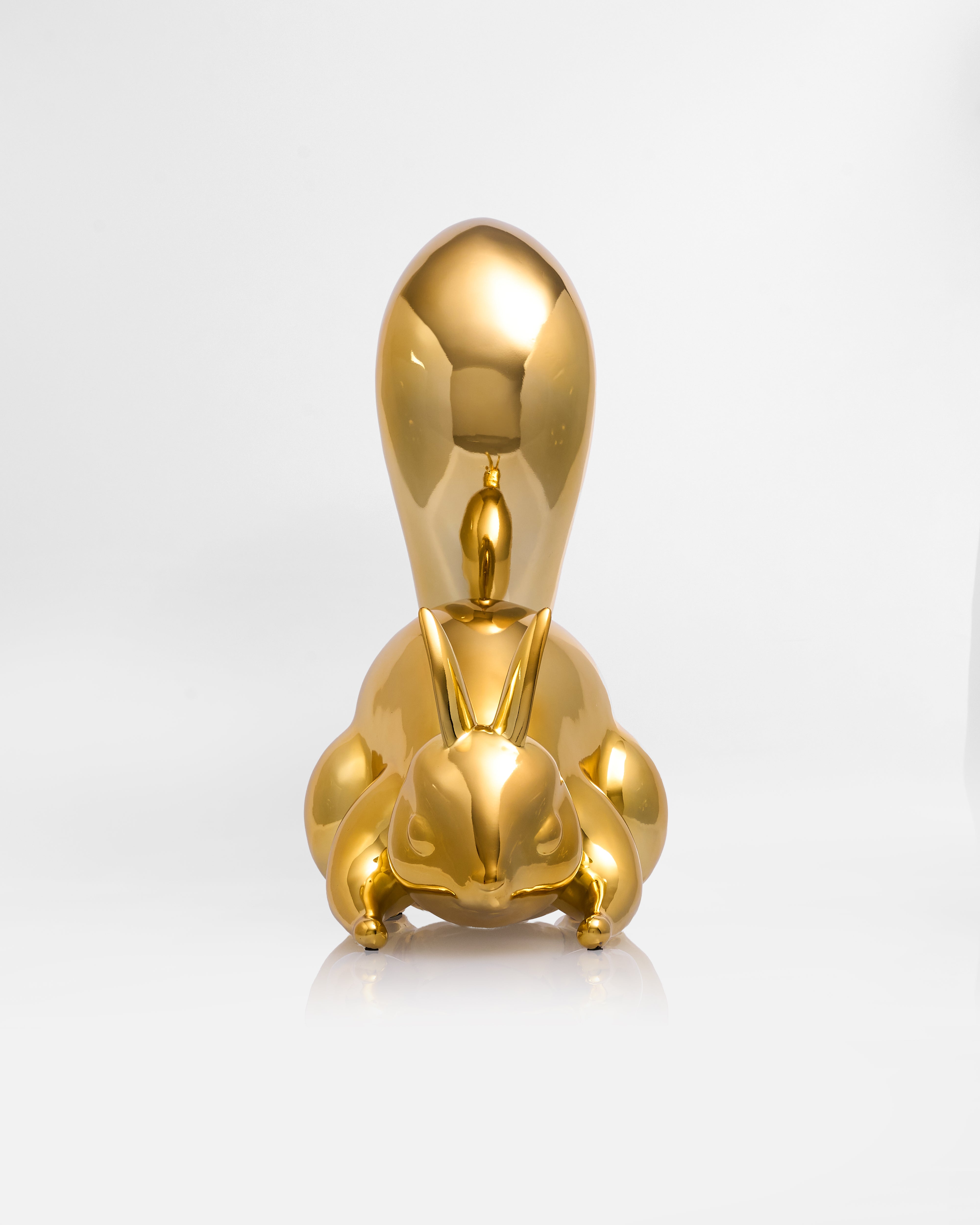 Gold sculpture of a rabbit on a white background