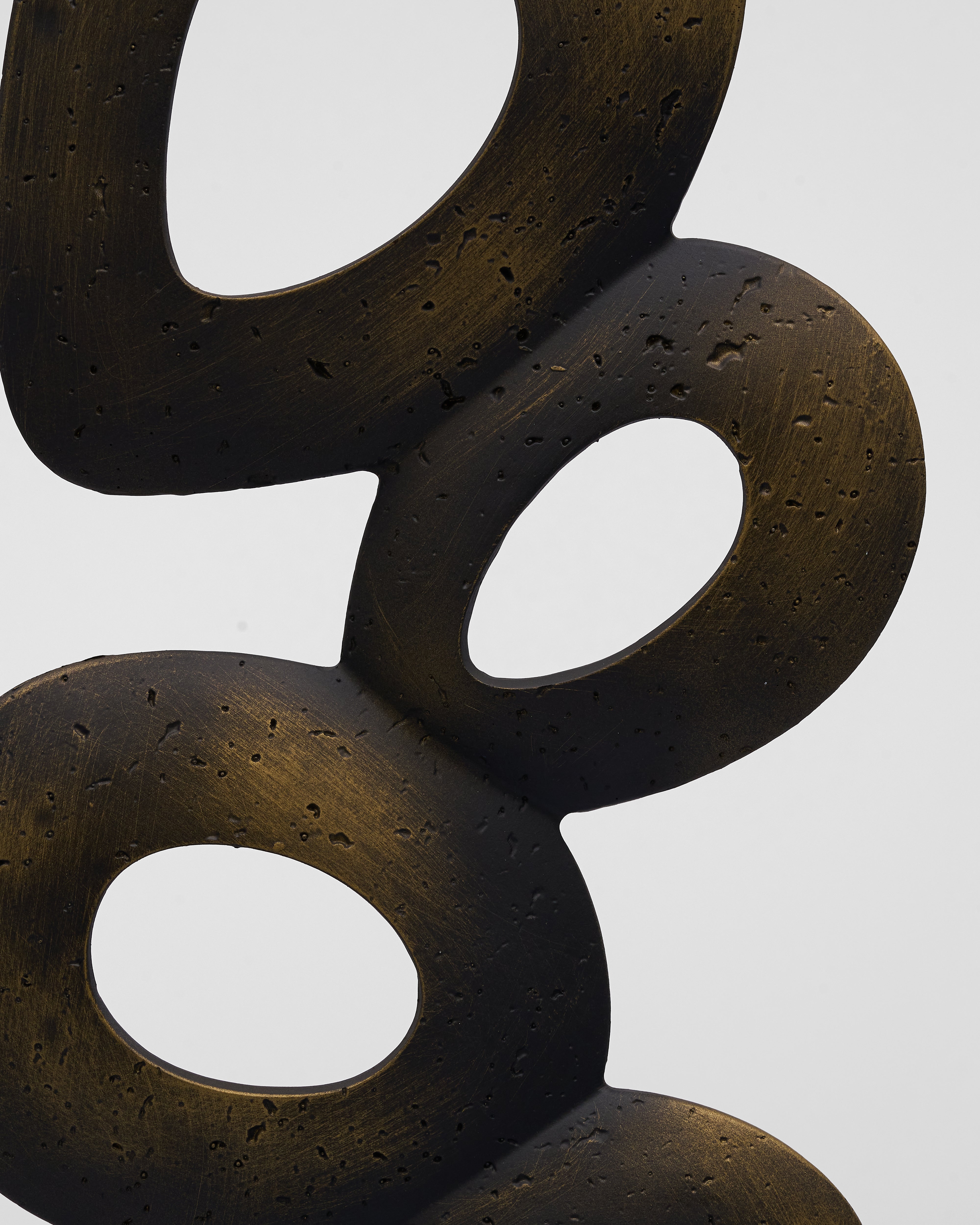 Abstract bronze color sculpture on a white background