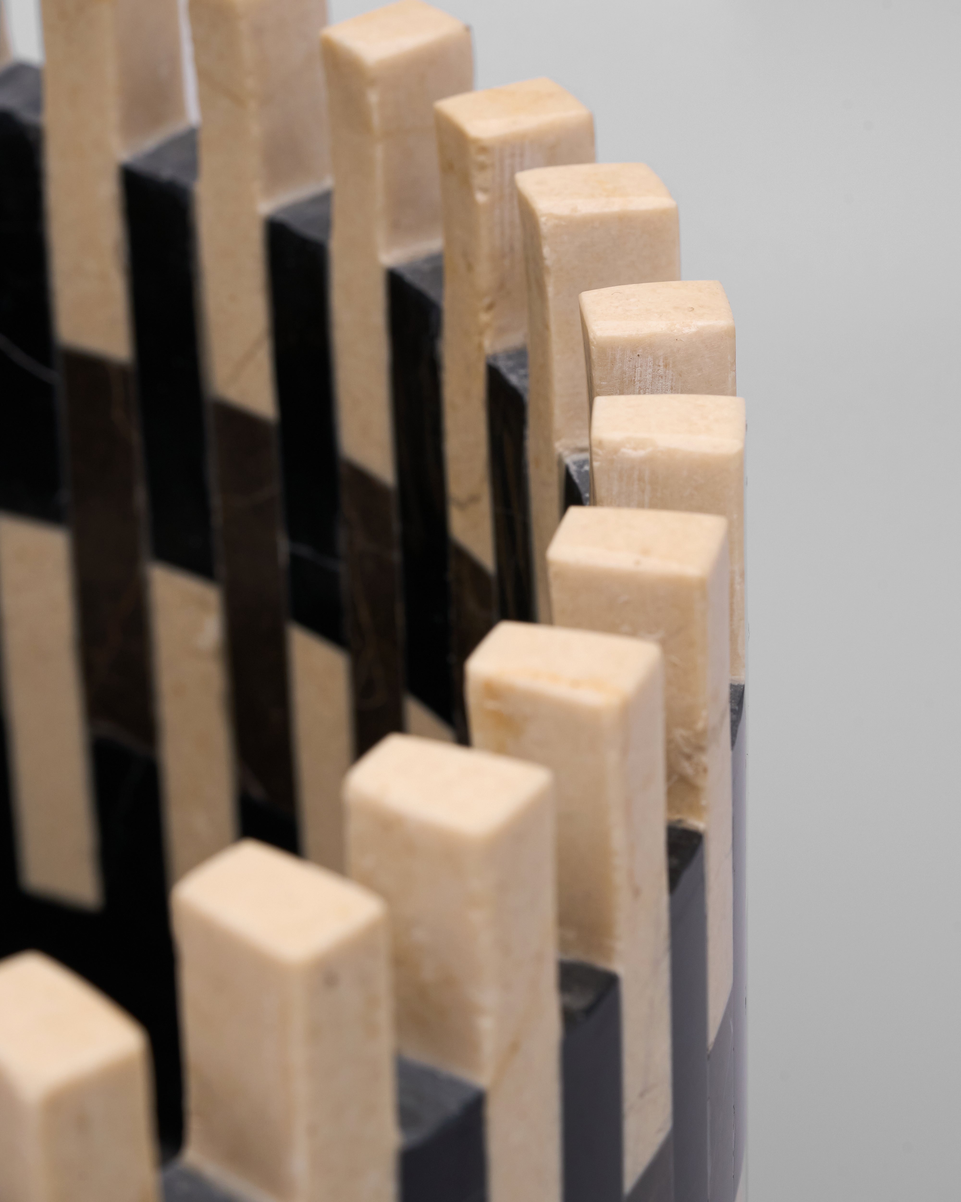Close-up of a chessboard with wooden pieces on a light gray background