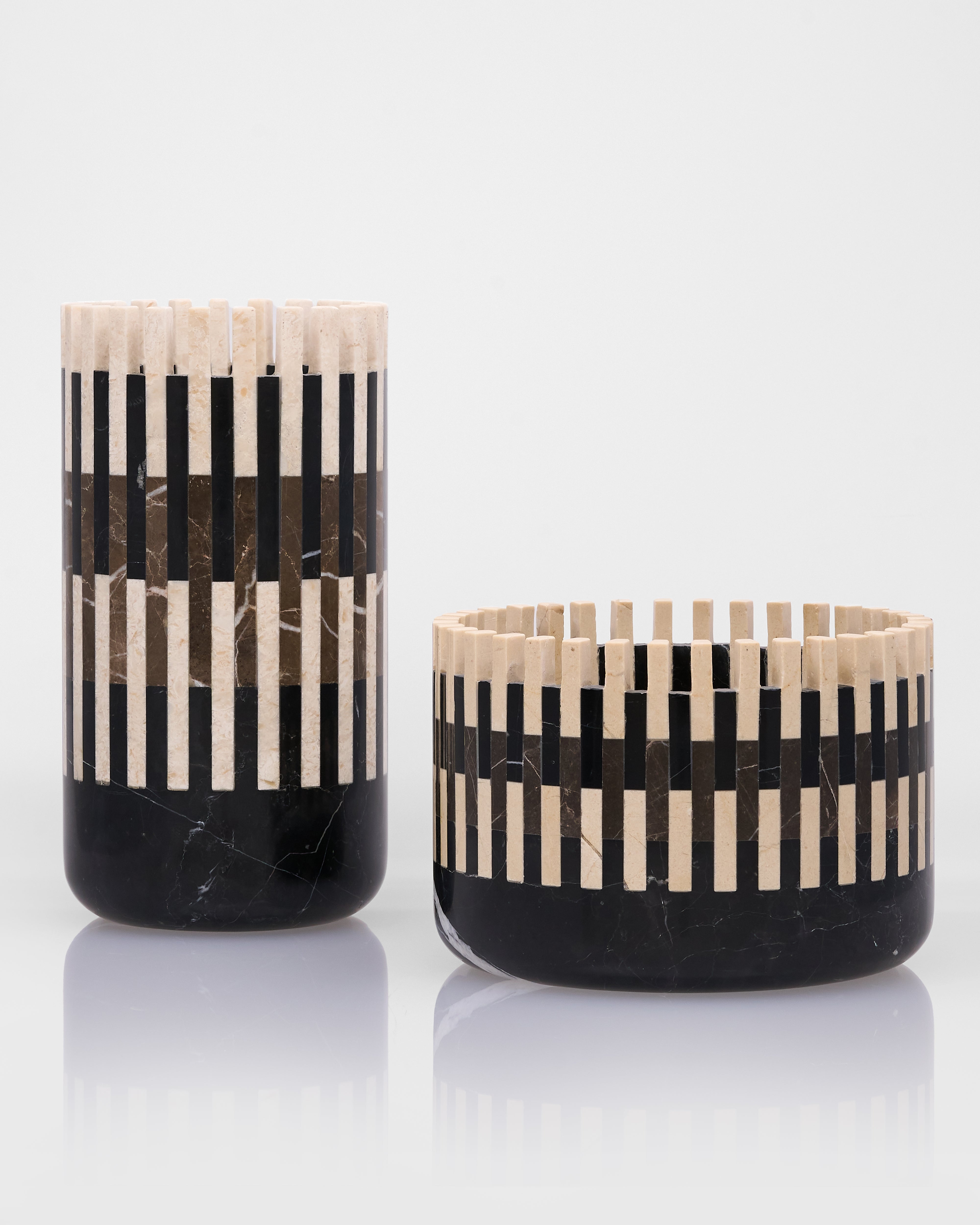 Two black and beige patterned vases on a white background