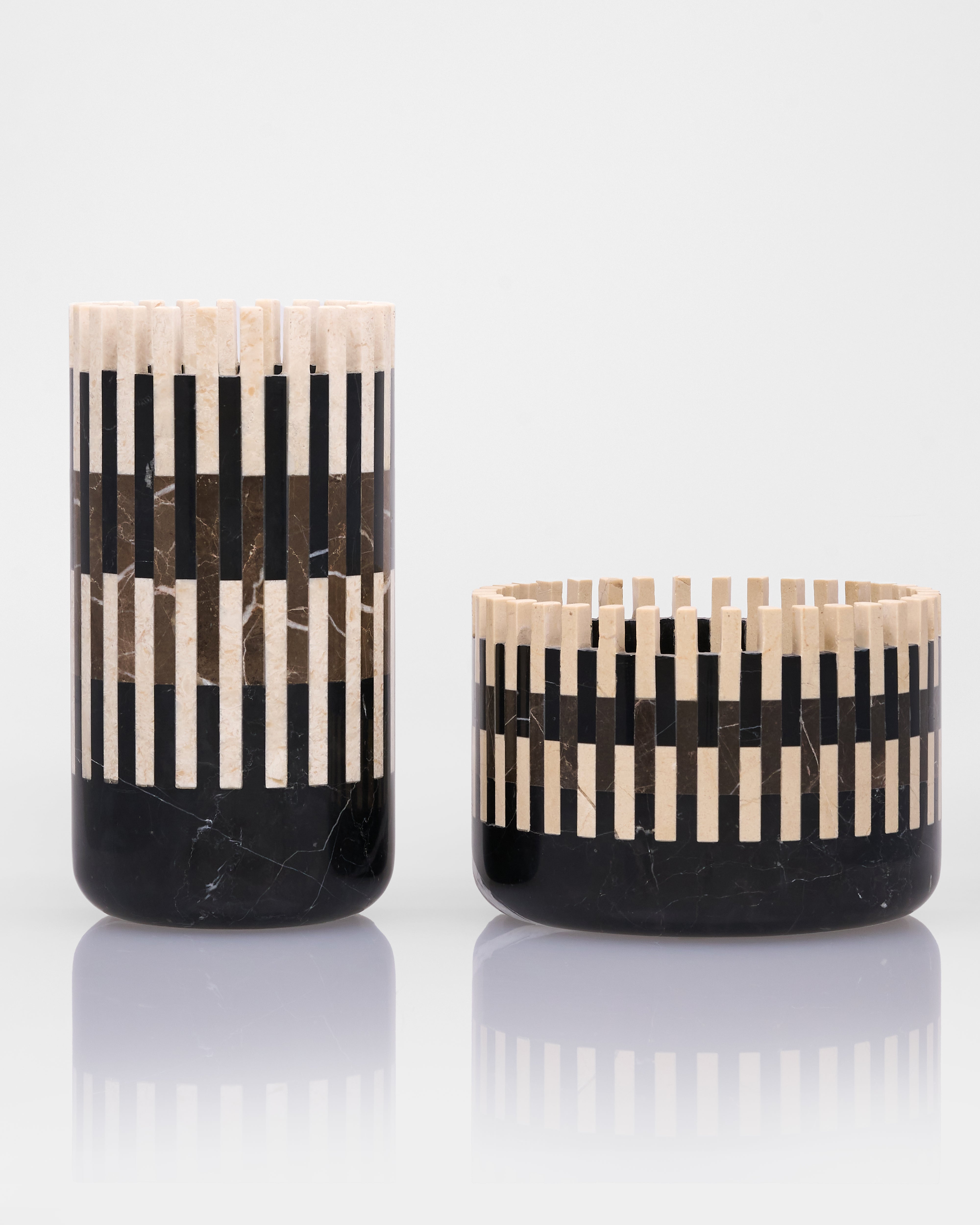 Two black and beige striped candle holders on a white background