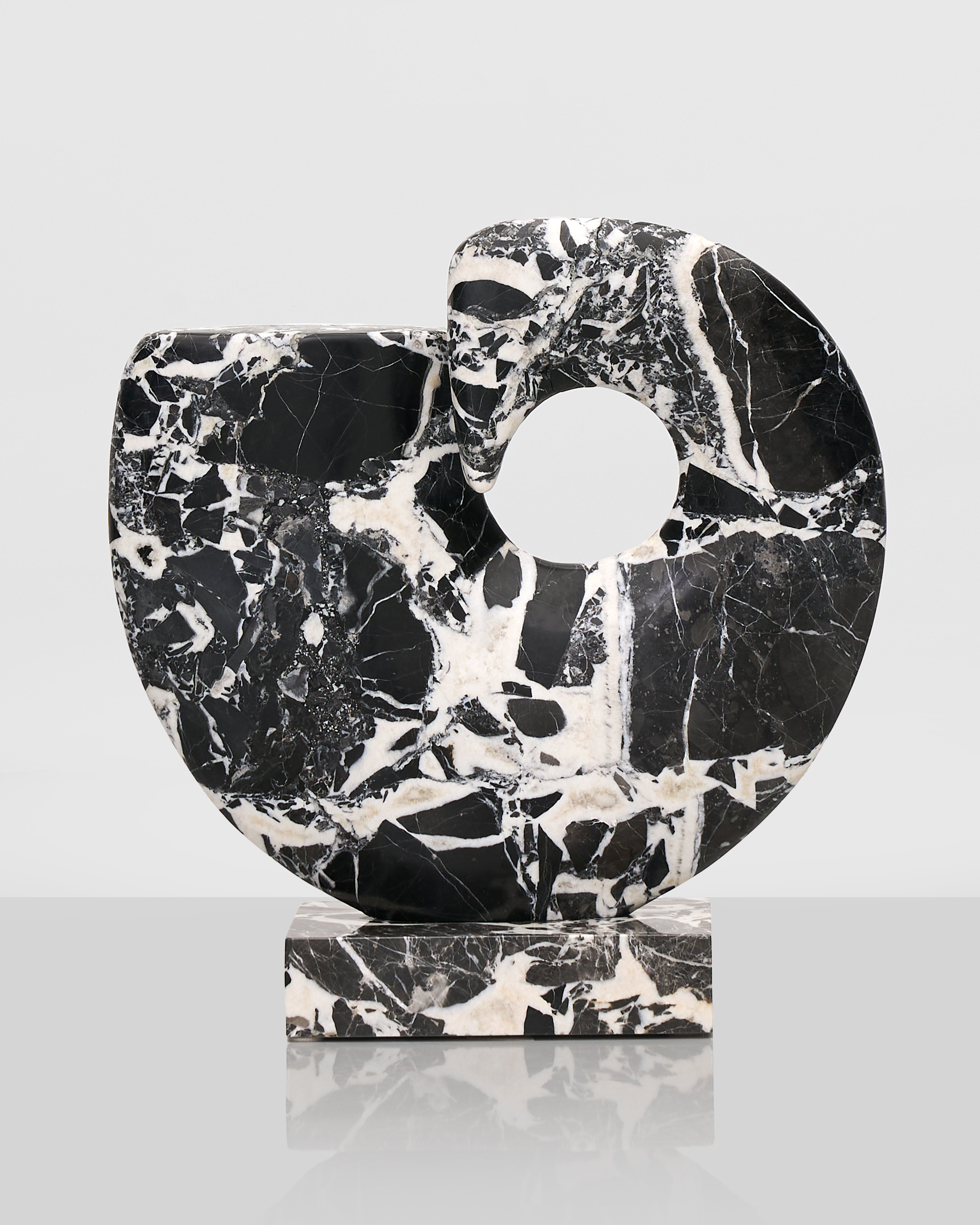 Black and white marble sculpture on a light gray background