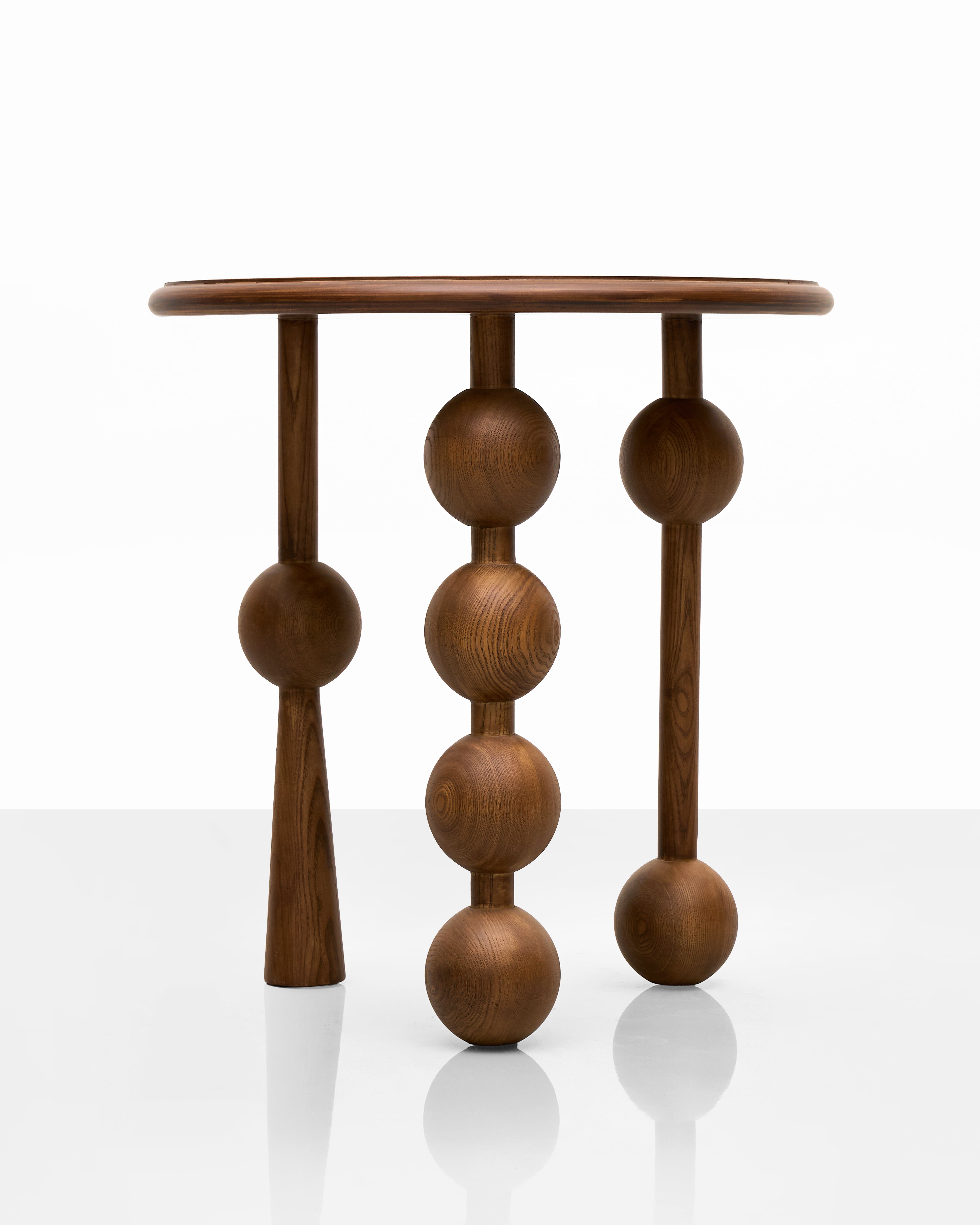 Wooden side table with spherical design on a white background