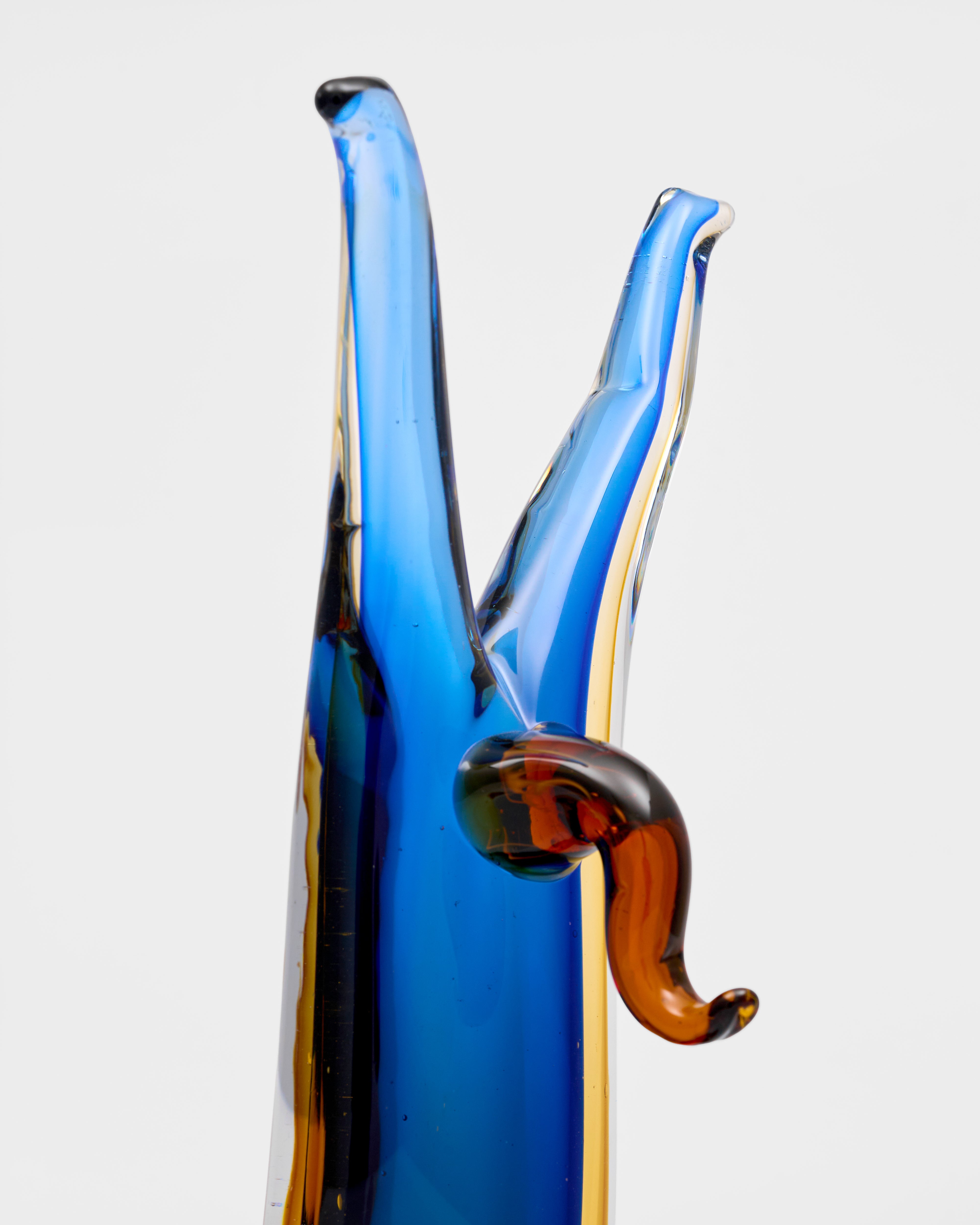 Glass sculpture with blue and brown colors on a white background