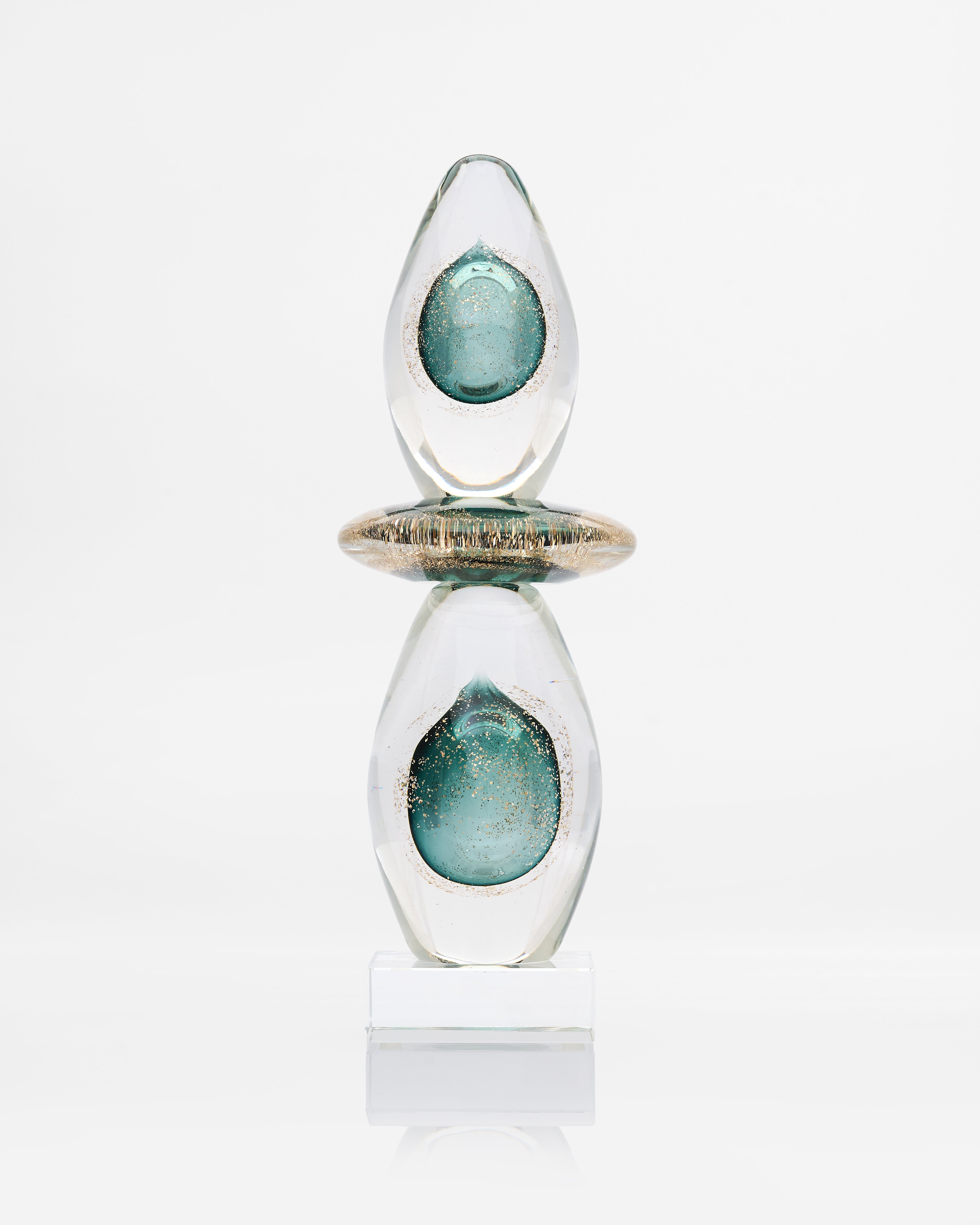 Decorative object with glass-like finish and teal interior on a white background