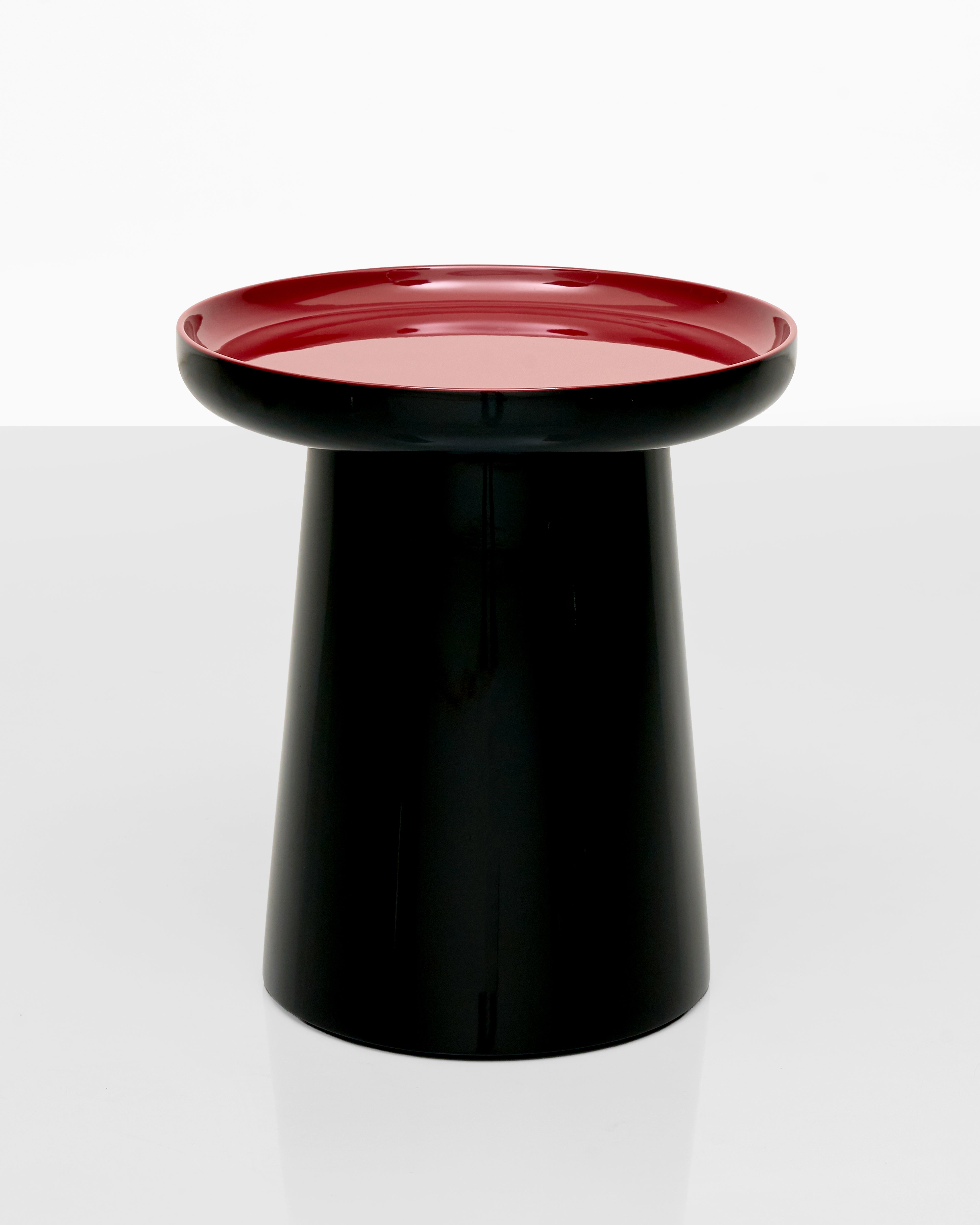 Black cylindrical object with a red top on a white background