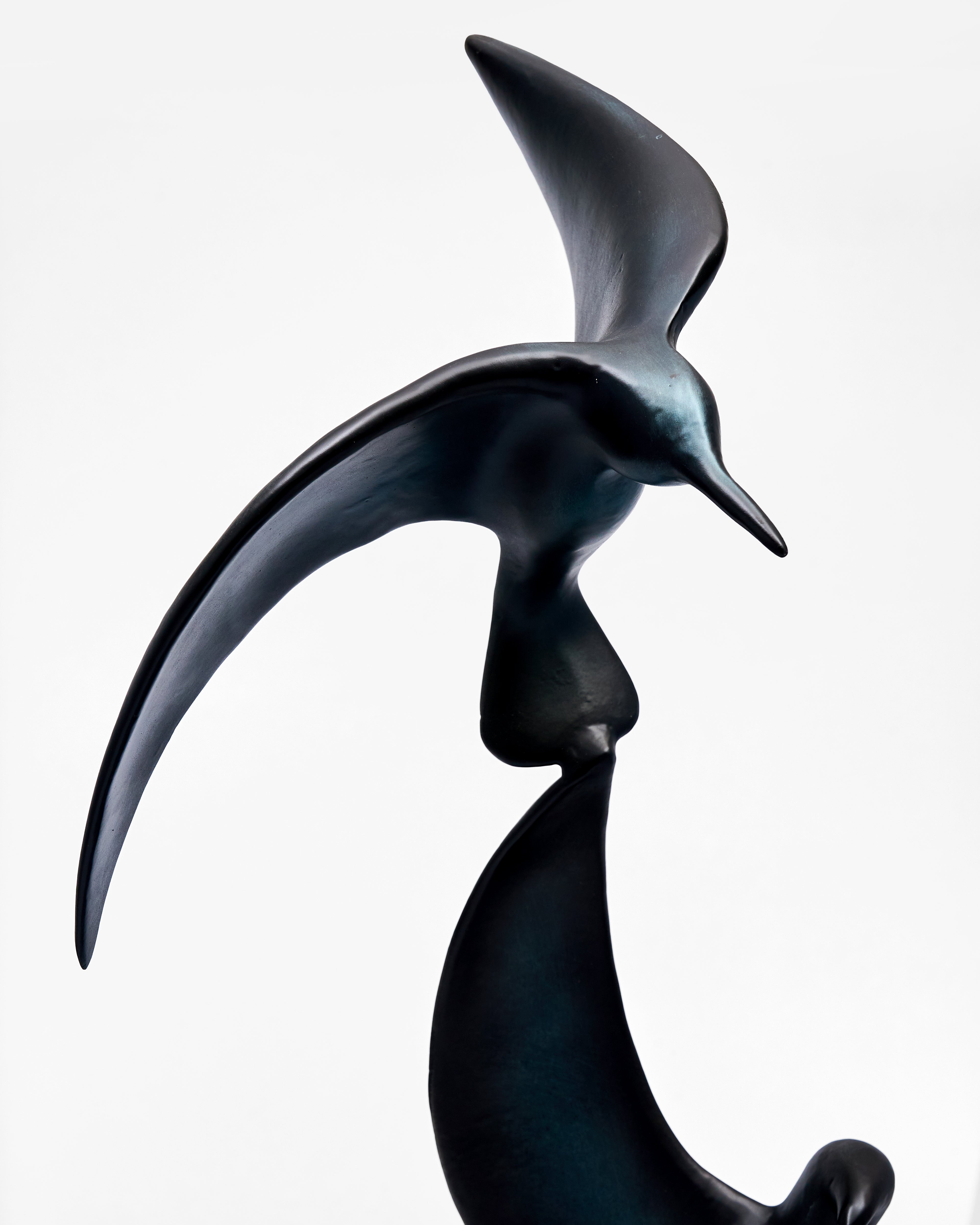 Black bird sculpture of a bird in flight on a white background