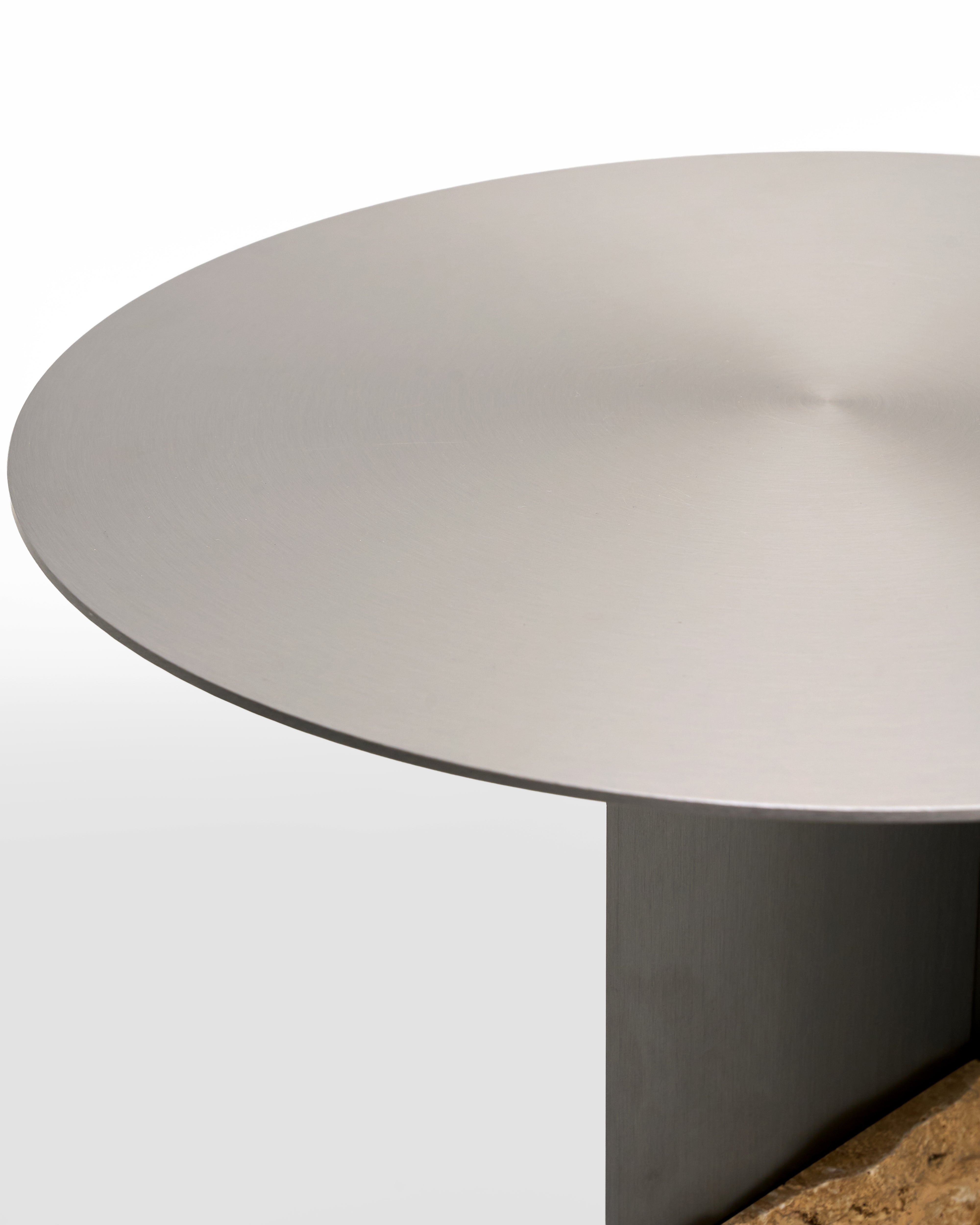 Round metal table with a metal surface on a white background