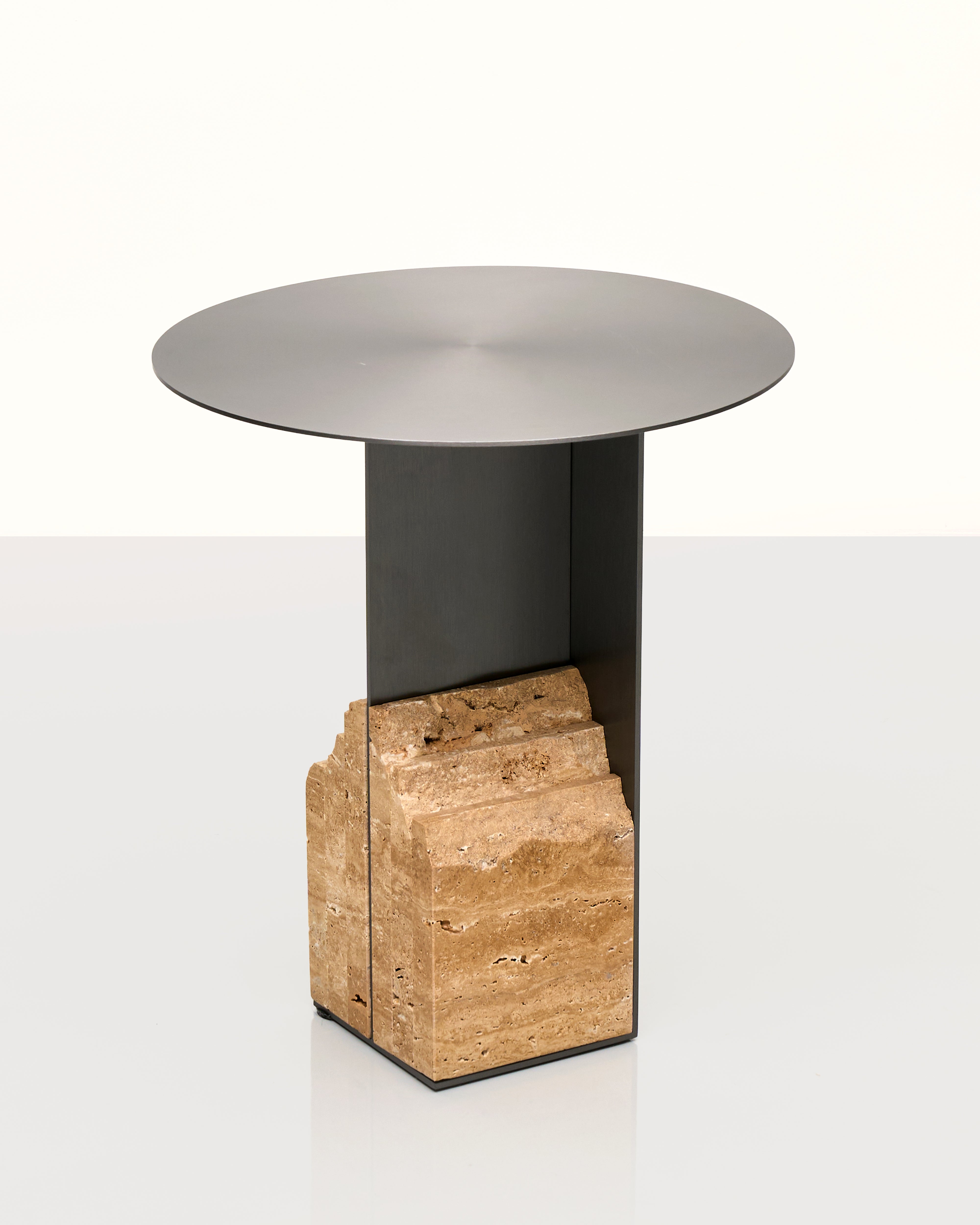Modern side table with a metallic top and stone base on a white background