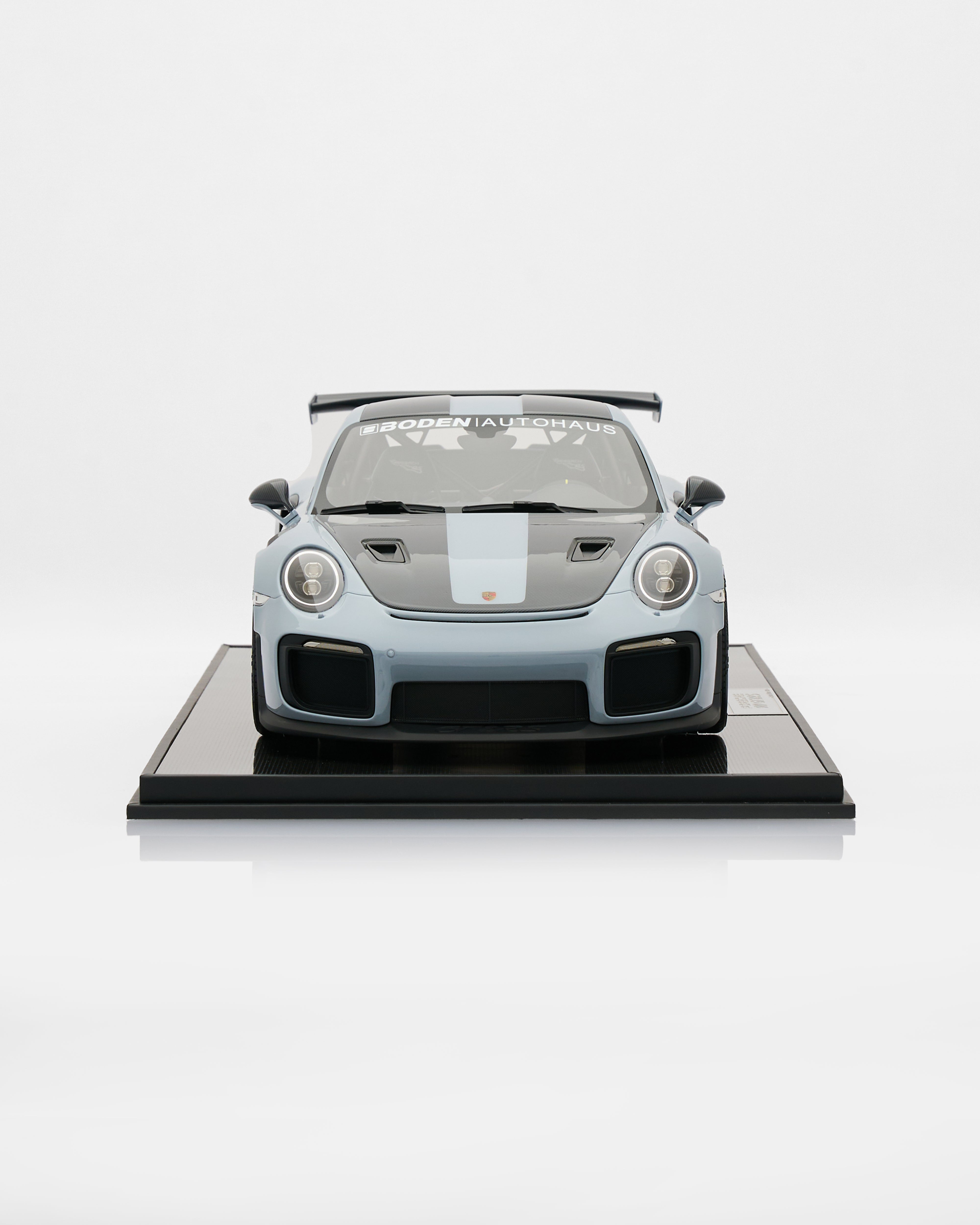 Porsche 911 GT2RS Chalk Gray car on a display stand with a white background