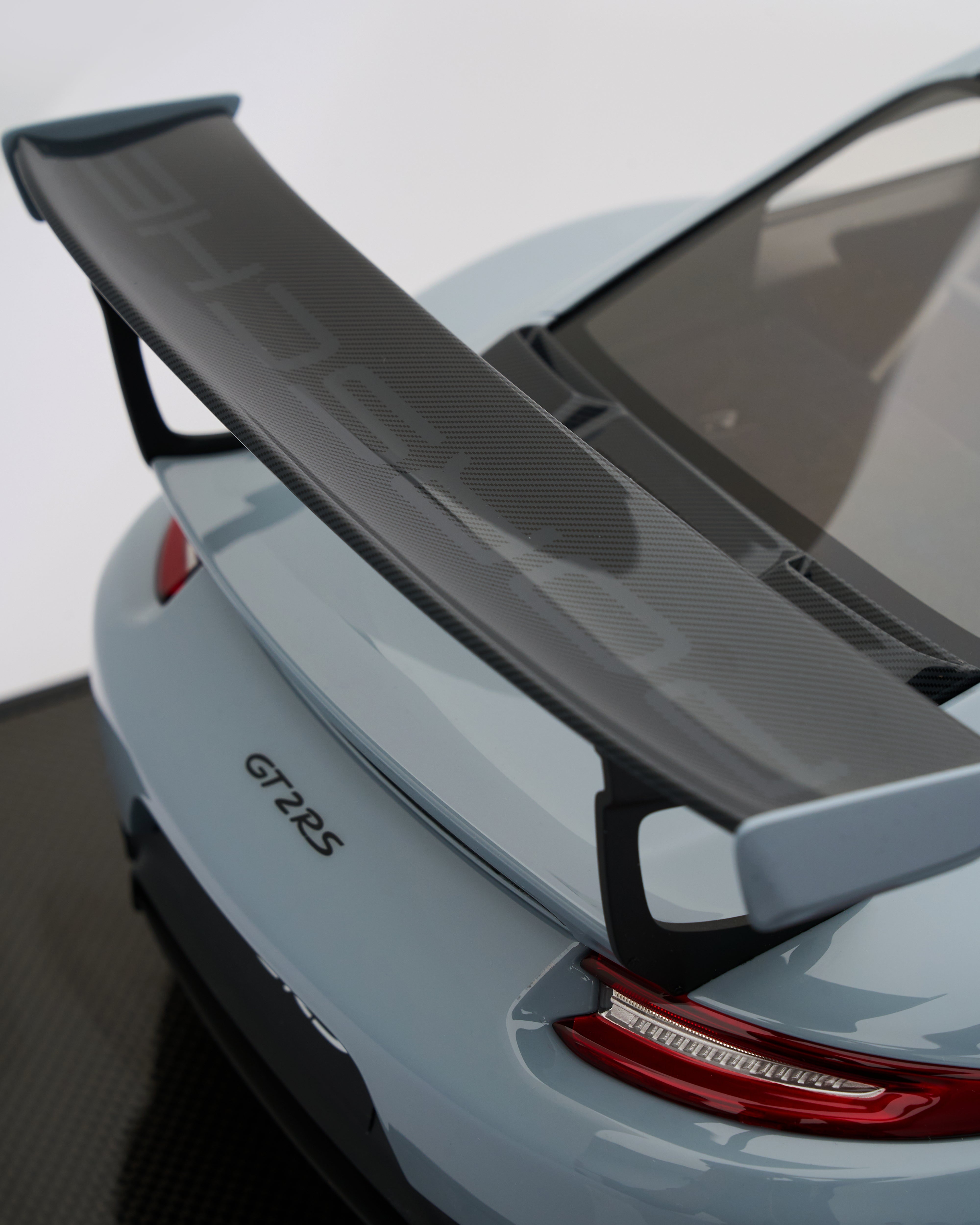 Porsche 911 GT2RS Chalk Gray Car with a large rear spoiler on a blurred background