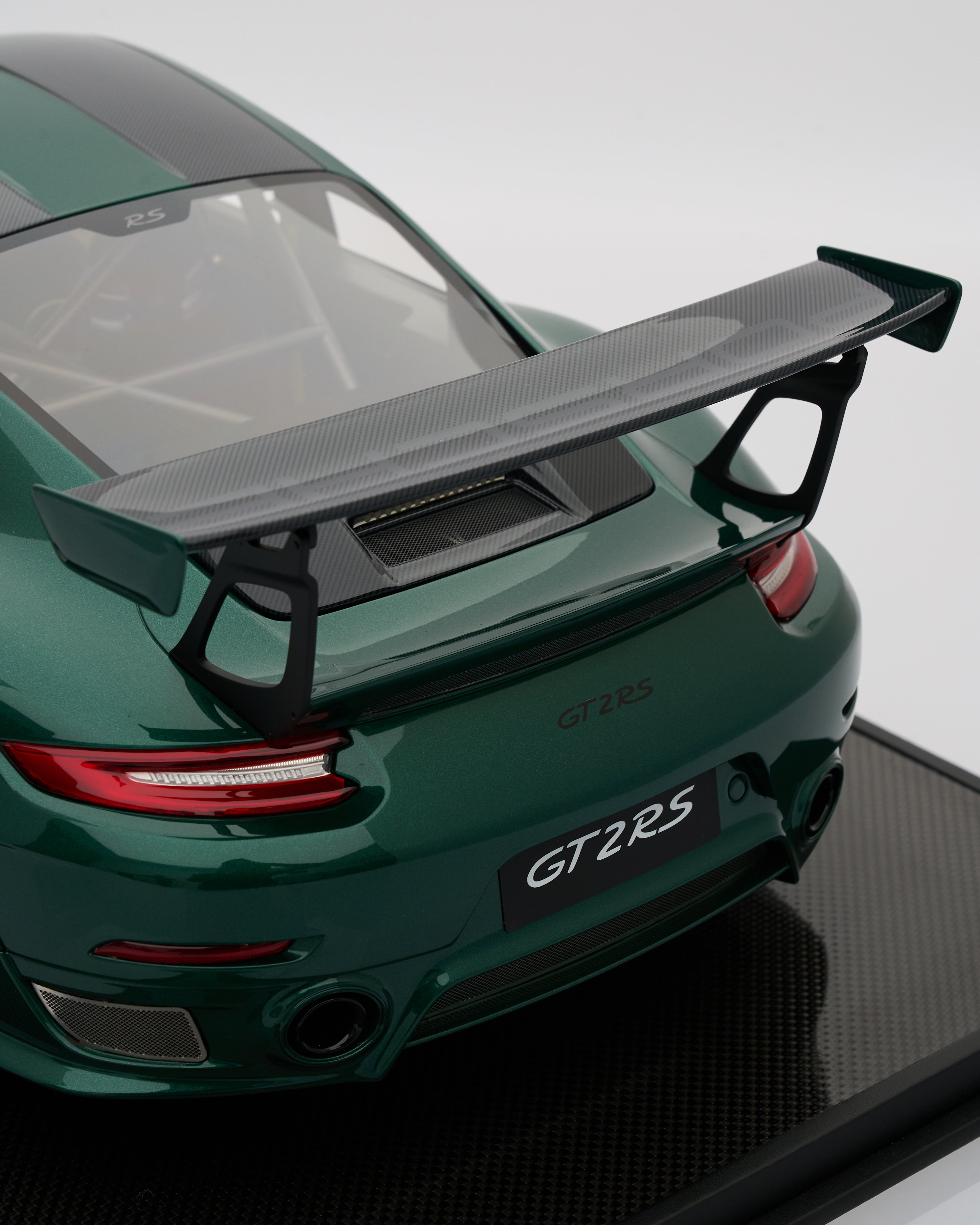 Green Porsche GT2 RS car with a large rear wing on a white background