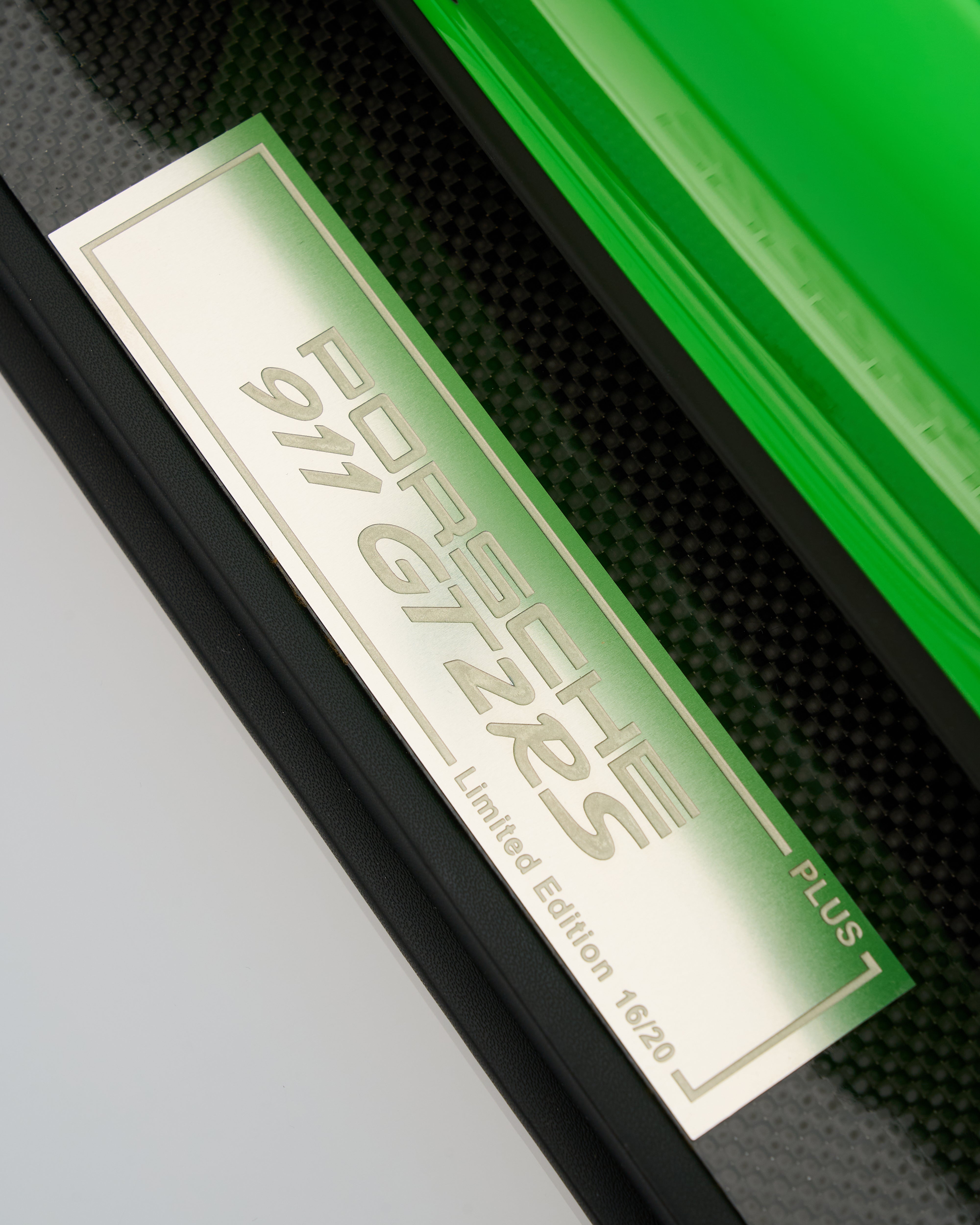 Close-up of a Porsche 911 GT2 RS Plus badge on a car door.
