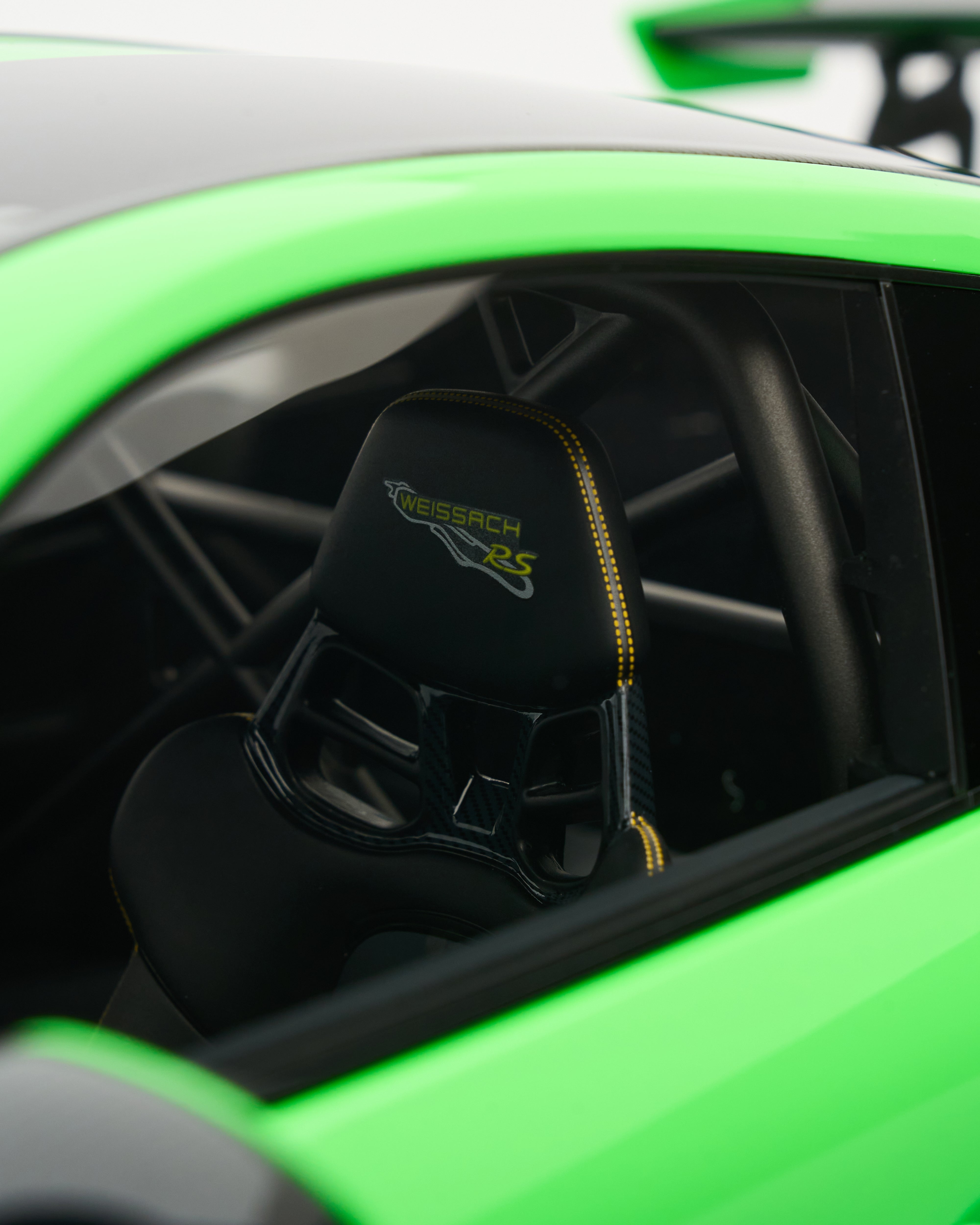 Black eat with 'Kreissach' branding inside a green car.