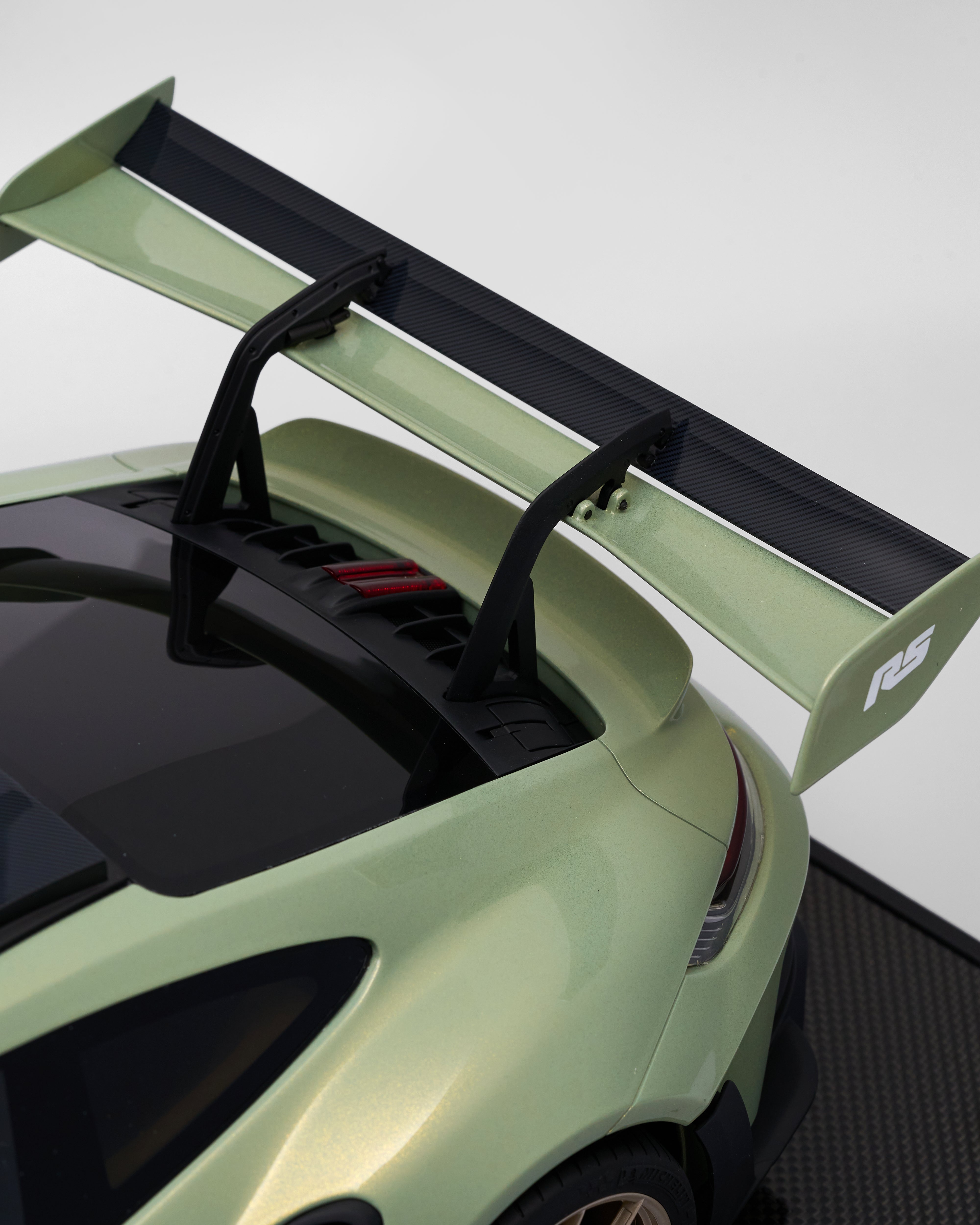 Close-up of a green car with a black spoiler on a white background