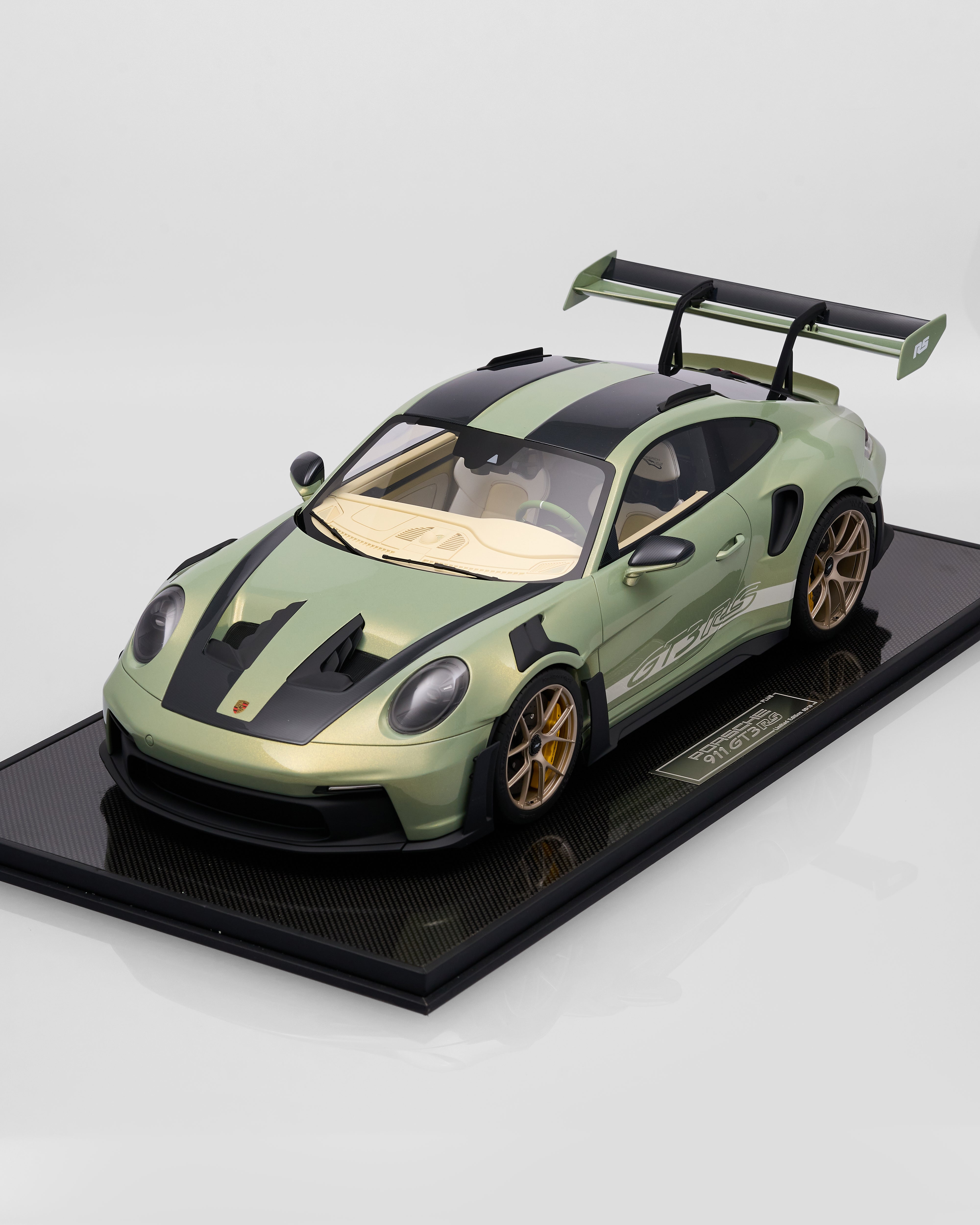 Model of a green sports car Porsche 911 GT3RS Nato Olive Green  on a black platform with a white background