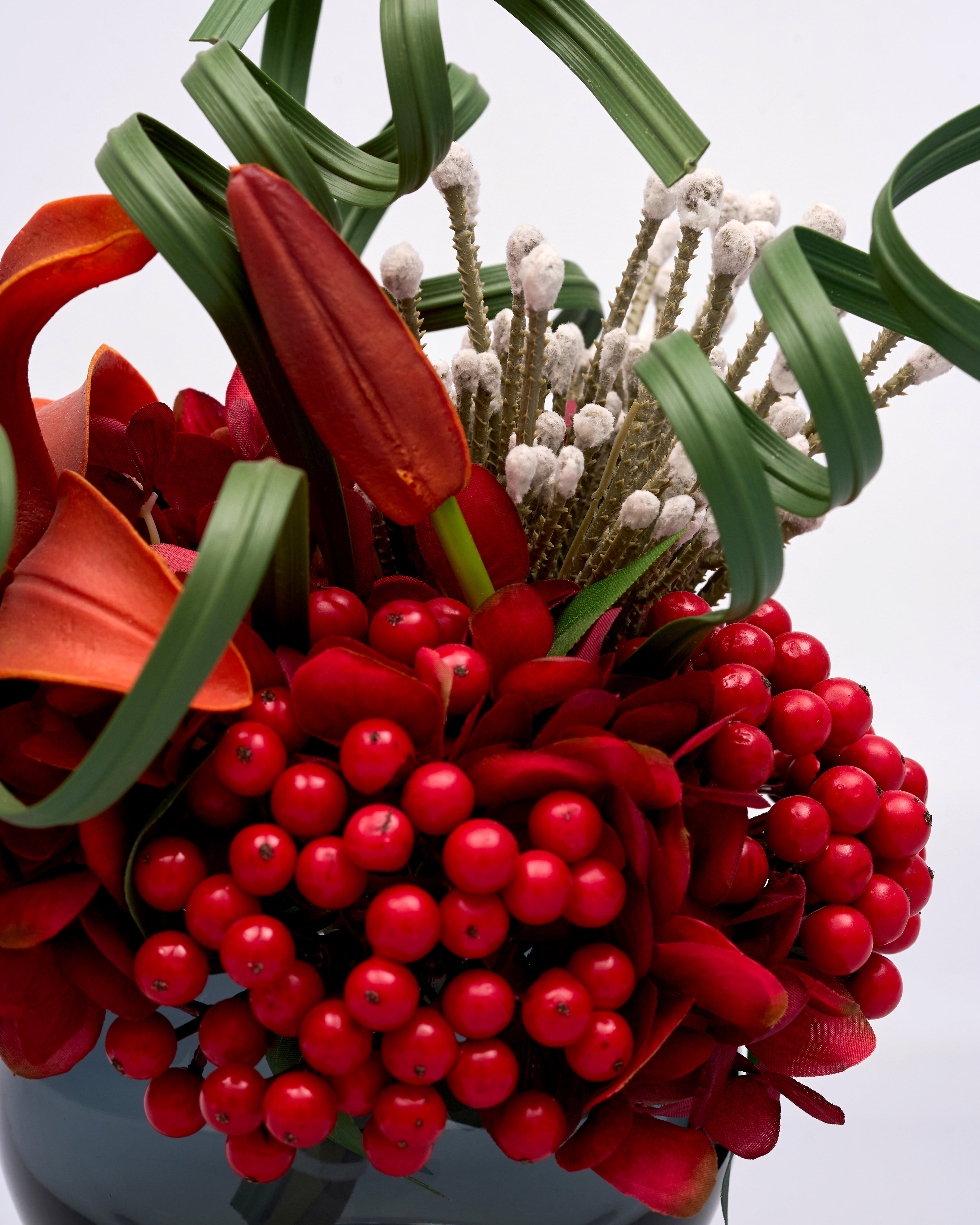 Bouquet with red flowers and berries on a light gray background