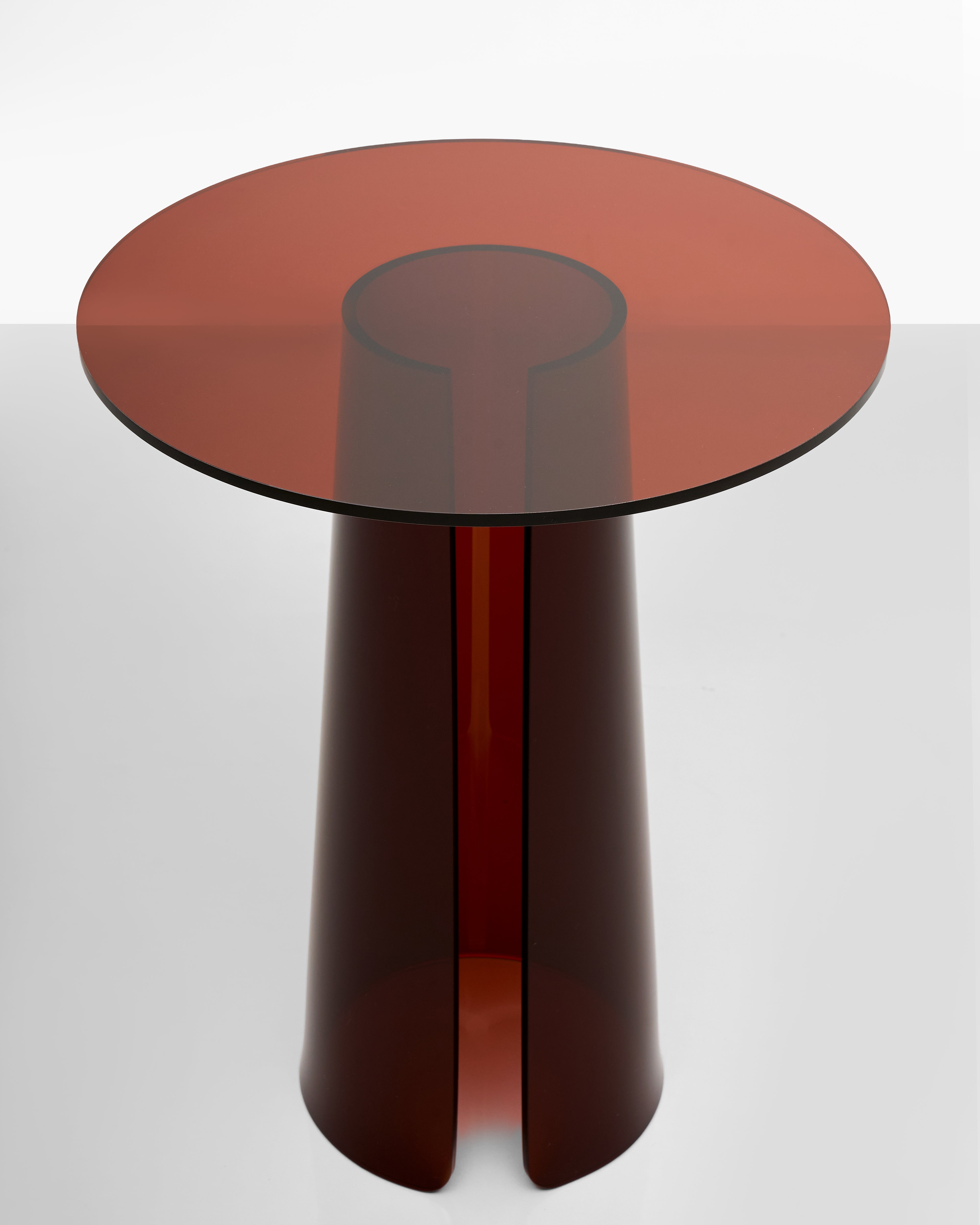 Round acrylic table with a dark brown cylindrical base on a white background